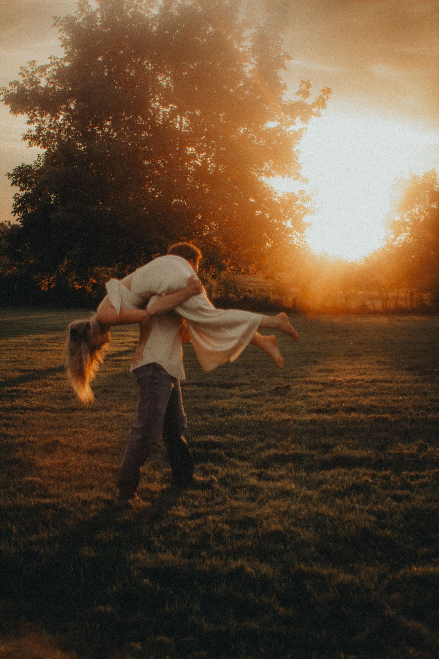 A couple, warm nostalgic light engagement session in Milaca, Minnesota, Guy carrying girl  Elk River, MN Photographer Photography Wedding
