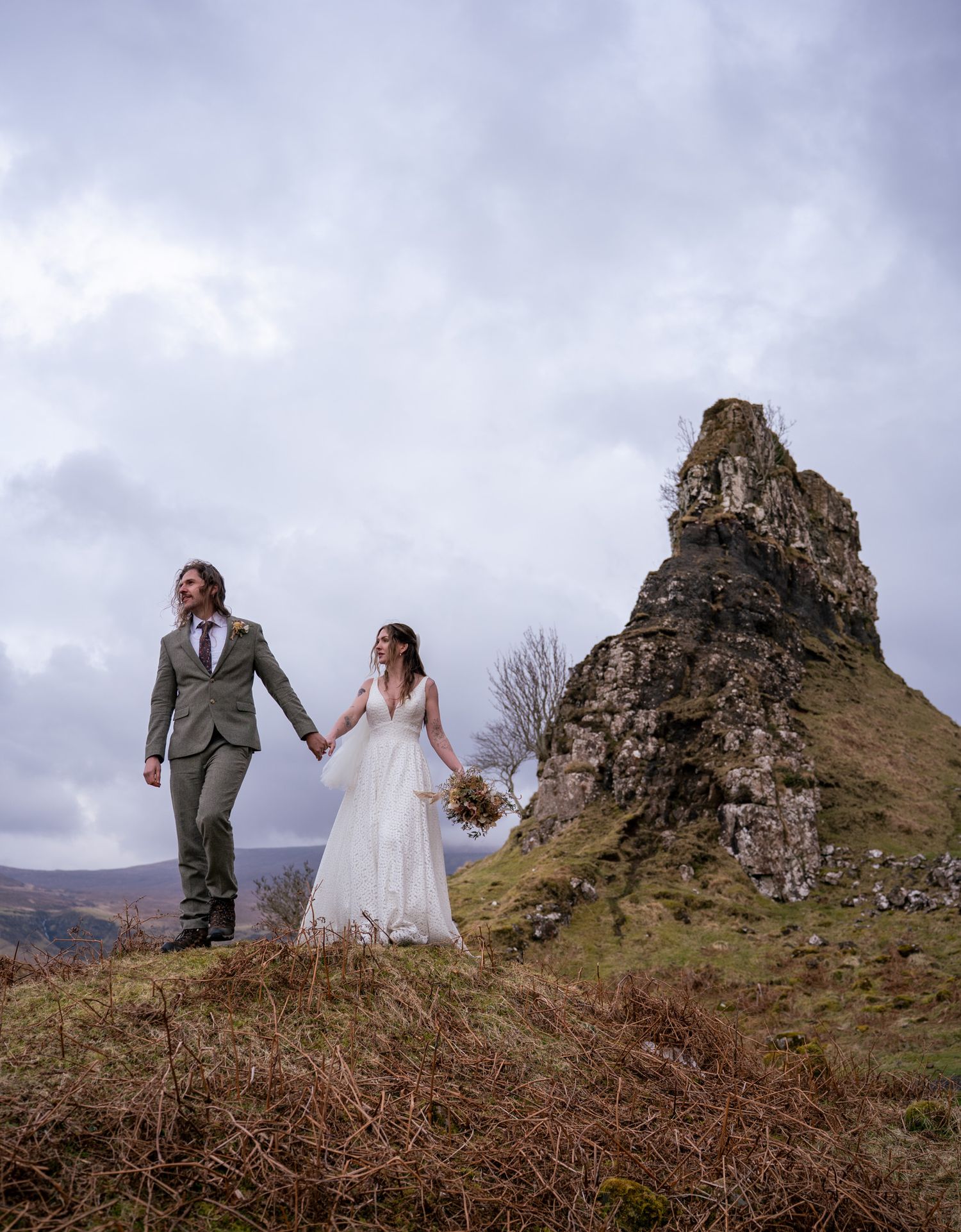Bride and groom walking hand in hand at Fairy Glen, Isle of Skye, intimate elopement photography capturing natural, romantic, and emotional