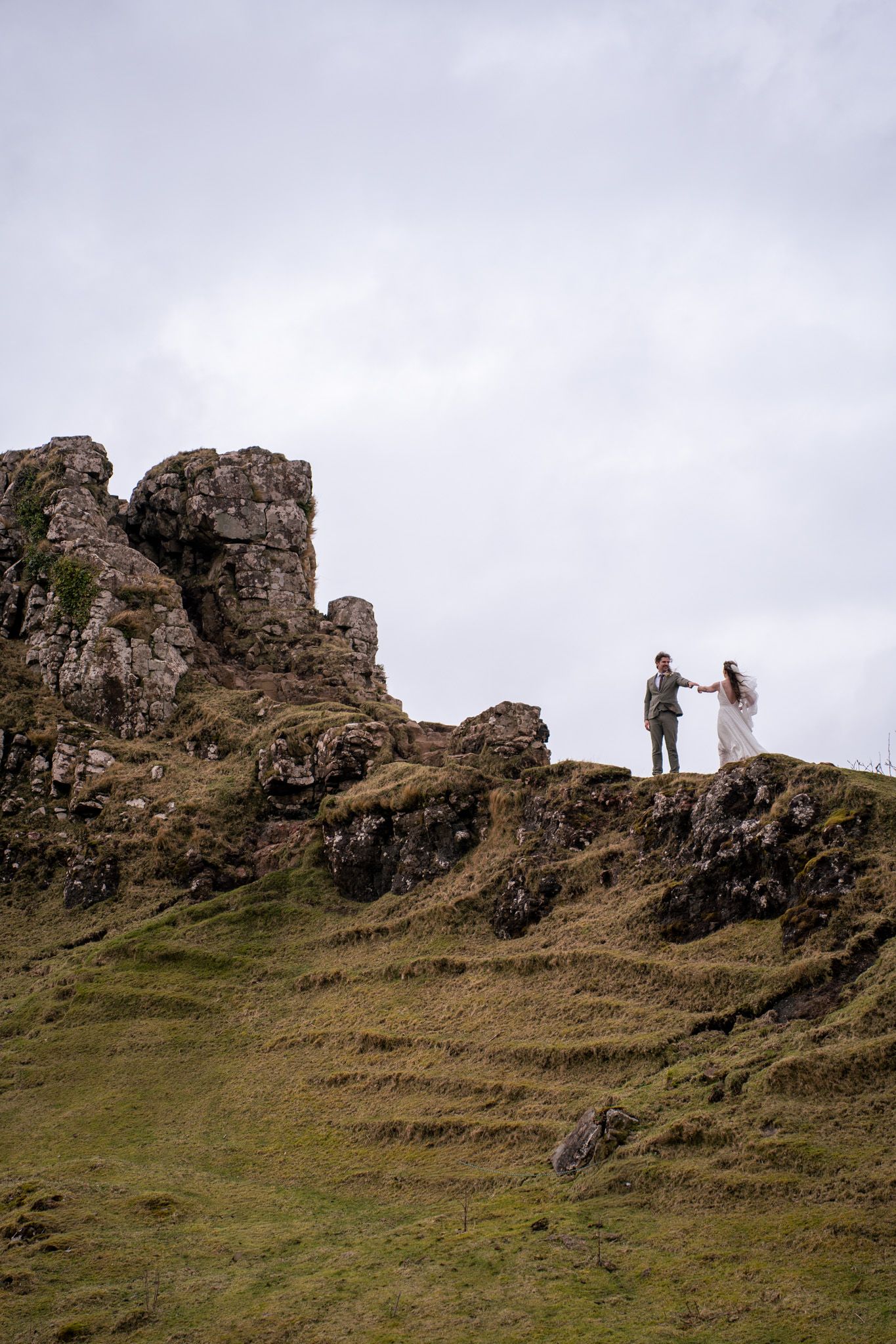 Bride and groom reaching out to each other at Fairy Glen, Isle of Skye, natural and romantic elopement photography capturing real emotion