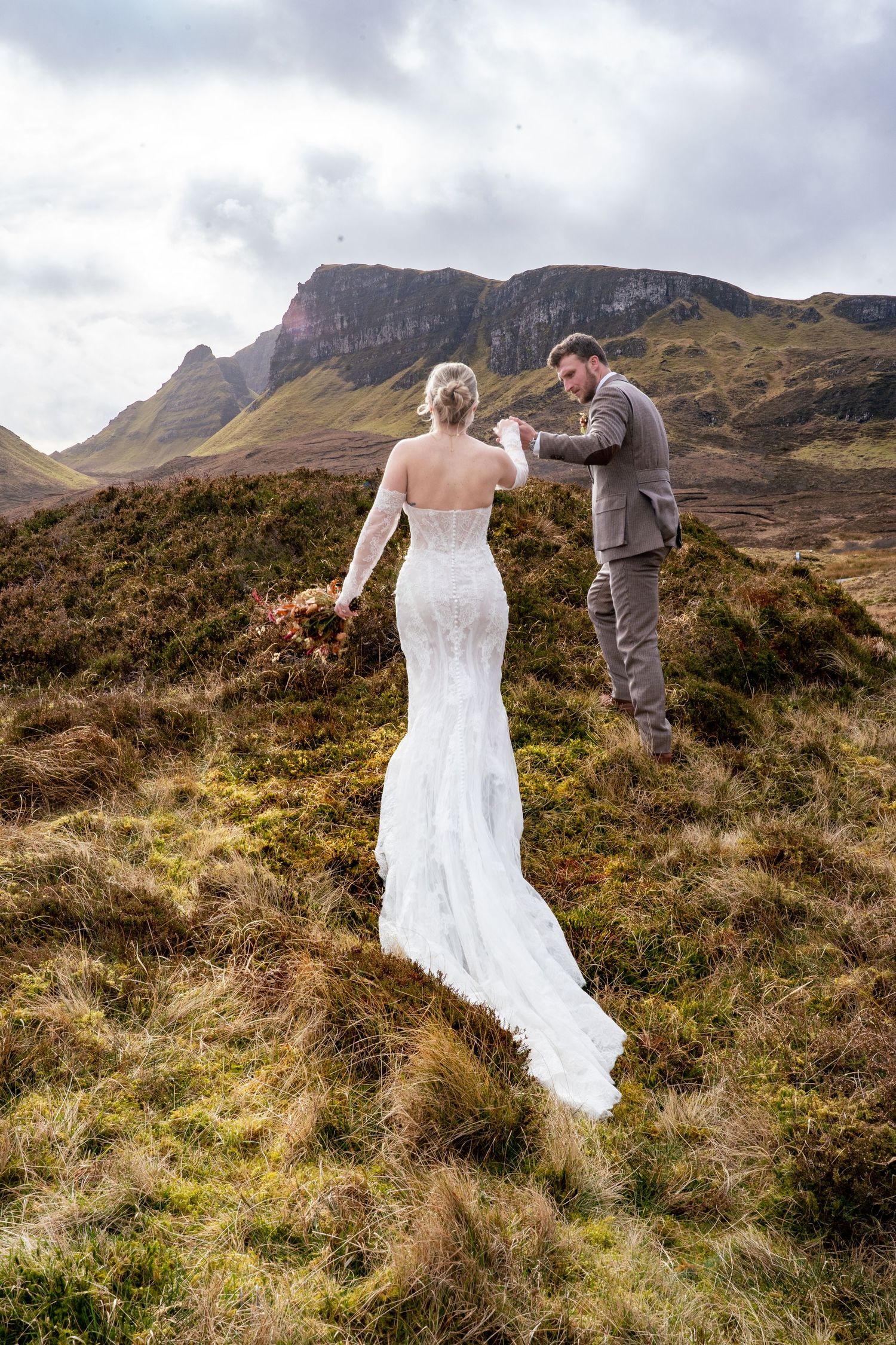 Bride and groom walking hand in hand at The Quiraing, Isle of Skye, romantic and natural wedding photography capturing authentic love and em