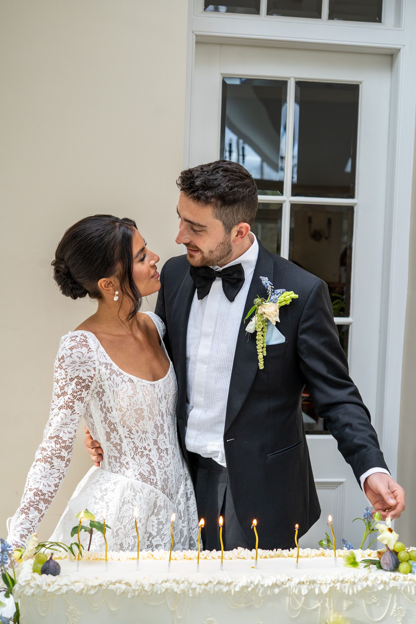 Bride and groom sharing a glance at their wedding cake, Edinburgh wedding photography in a candid and heartfelt style