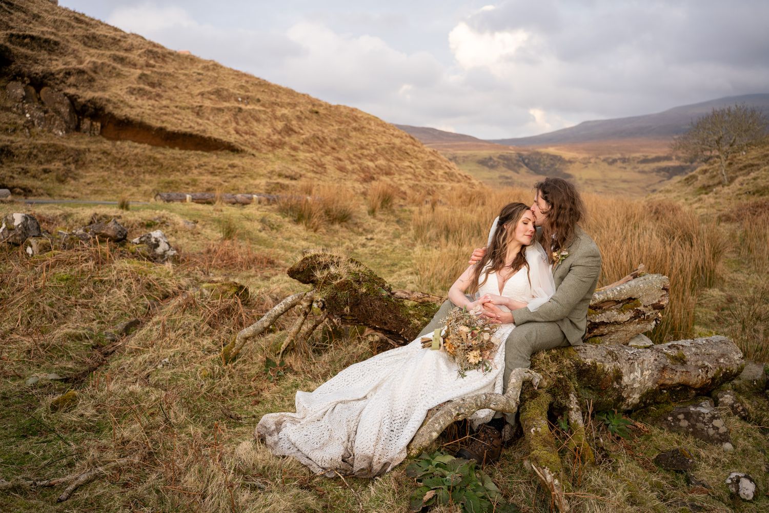 Groom holding bride in natural landscape at Isle of Skye, romantic and emotional wedding photography capturing authentic love and adventure