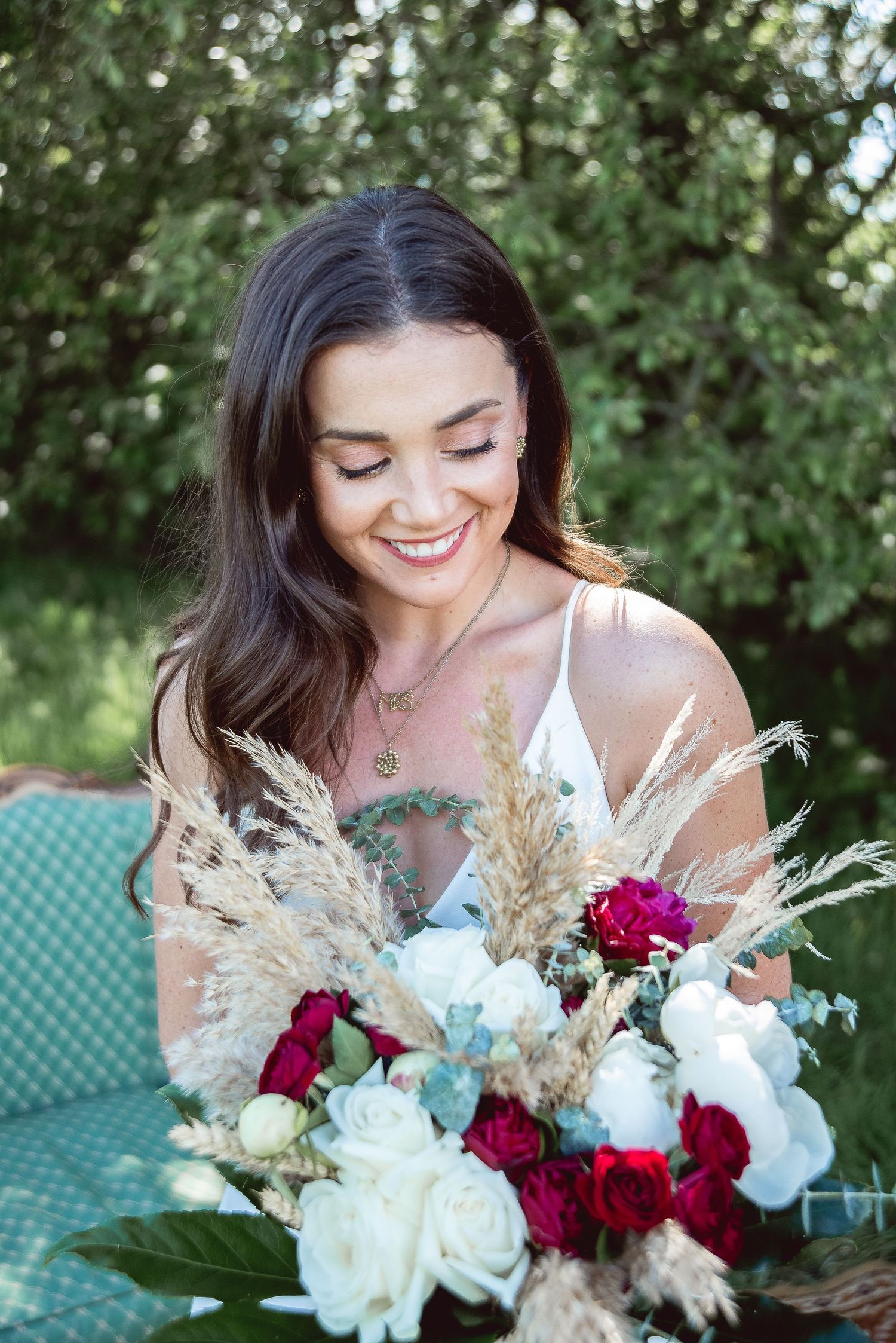 A beautiful bouquet featuring burgundy and white flowers with dried pampas grass elements in an outdoor setting.