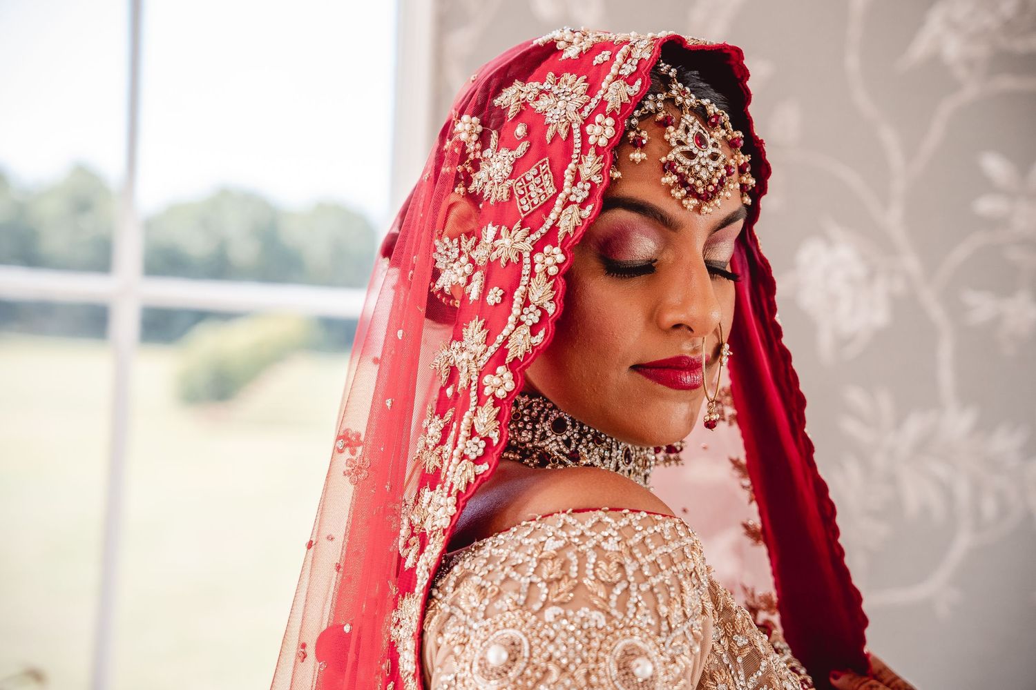 Close up portrait of Indian Bride in Red and Gold Saree and jewellery