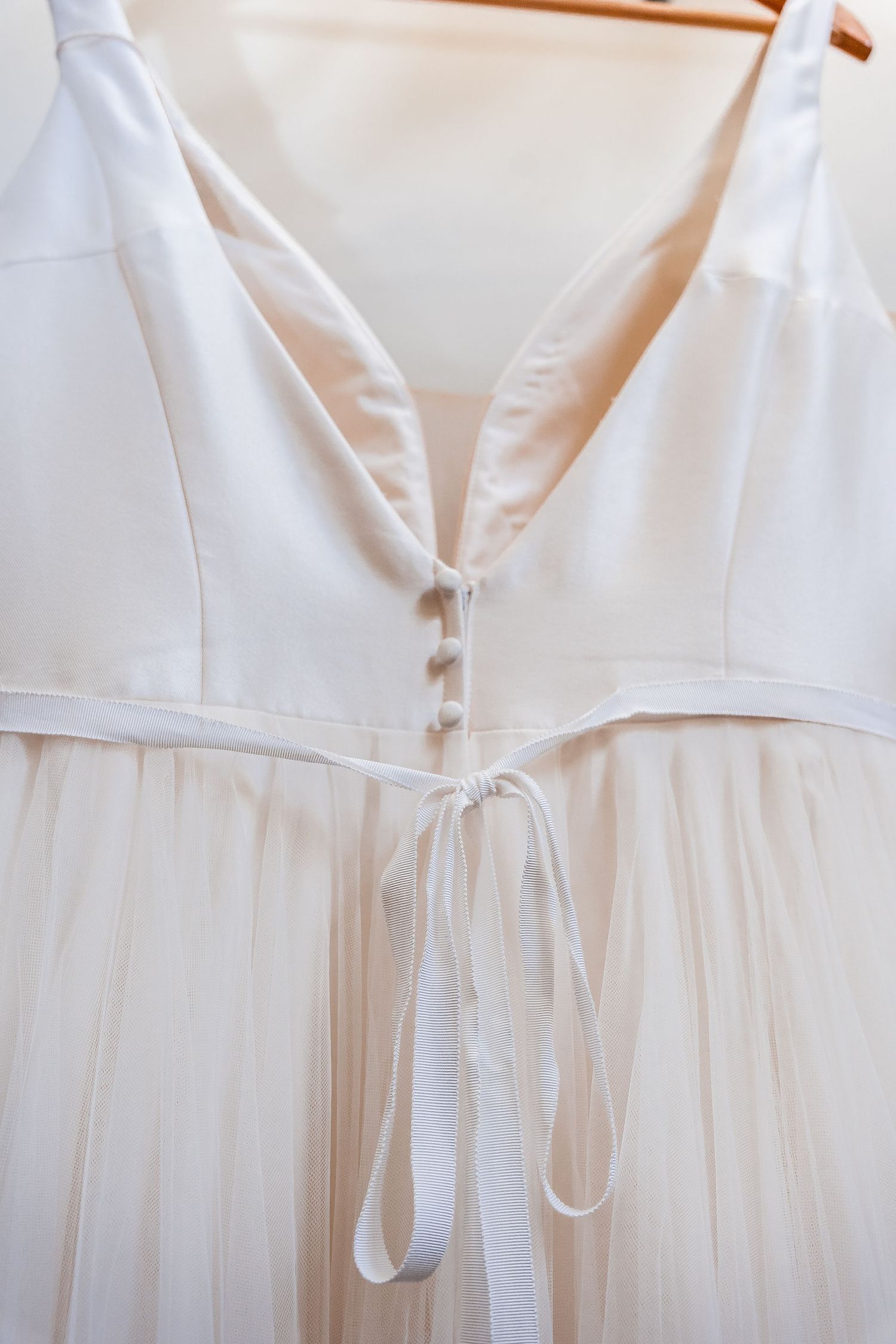 Close up of Bridal gown's back with buttons and bow detail