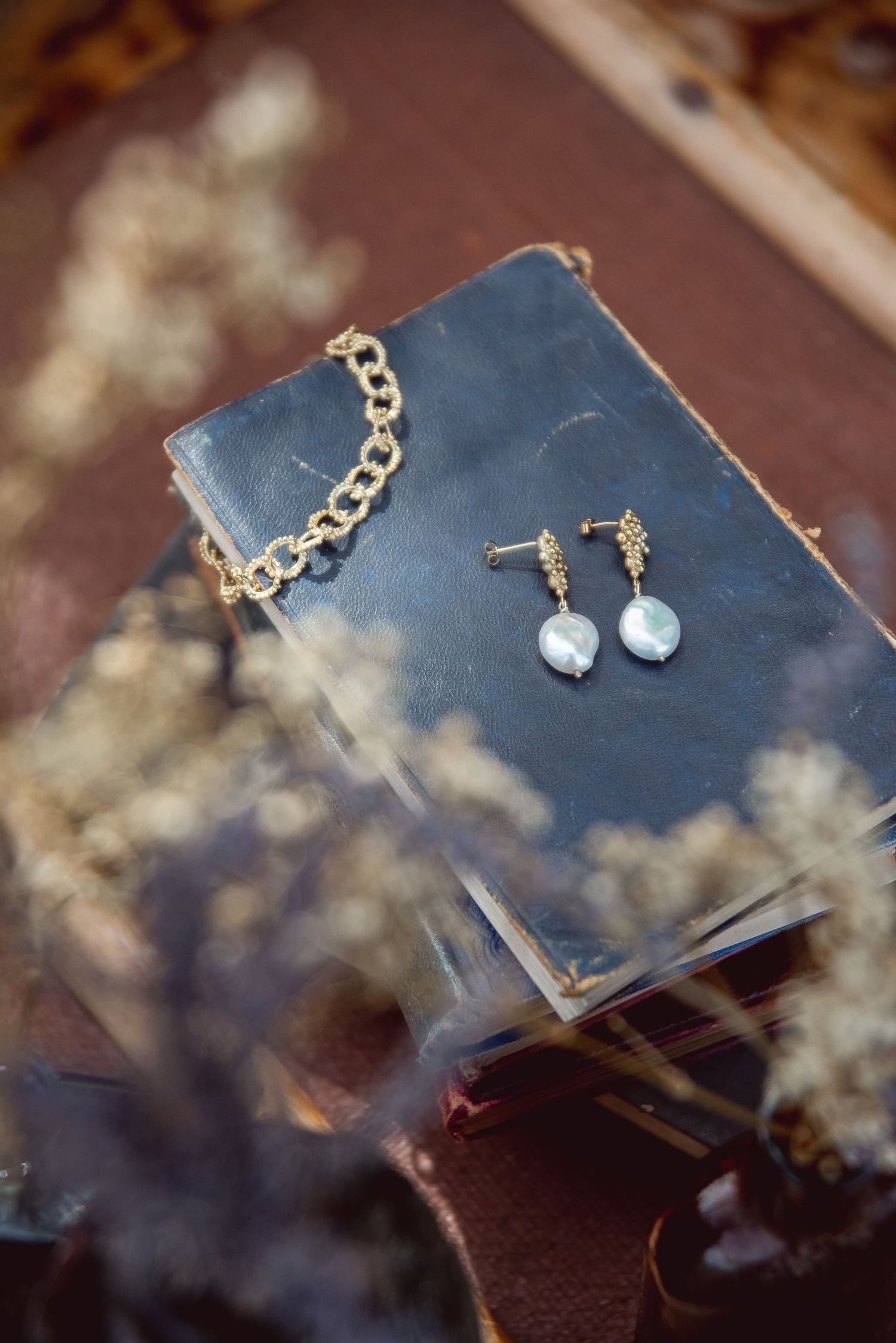 Elegant pearl earrings and jewelry displayed on a dark textured surface.