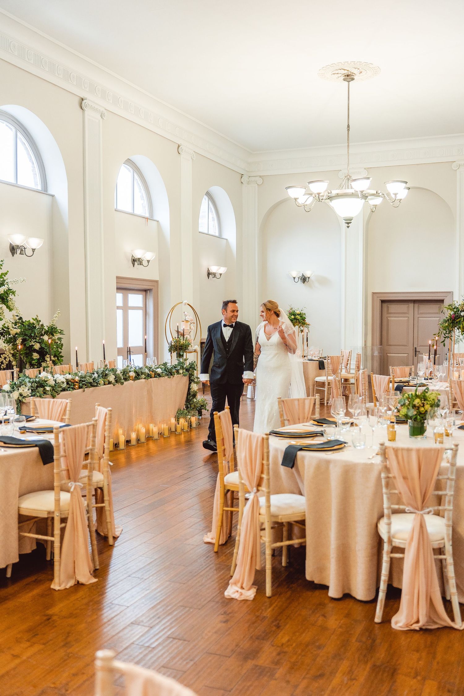 Bride and Groom walking in the middle of decorated reception room