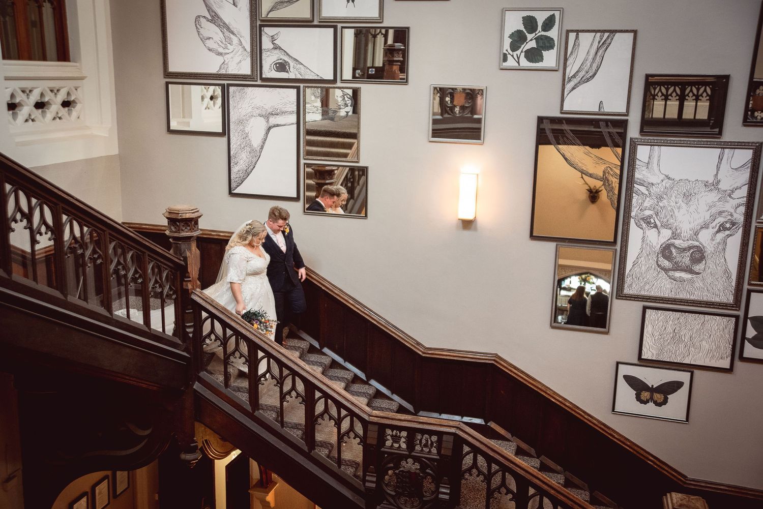 An elegant staircase with framed artwork decorating the walls in a historic building.