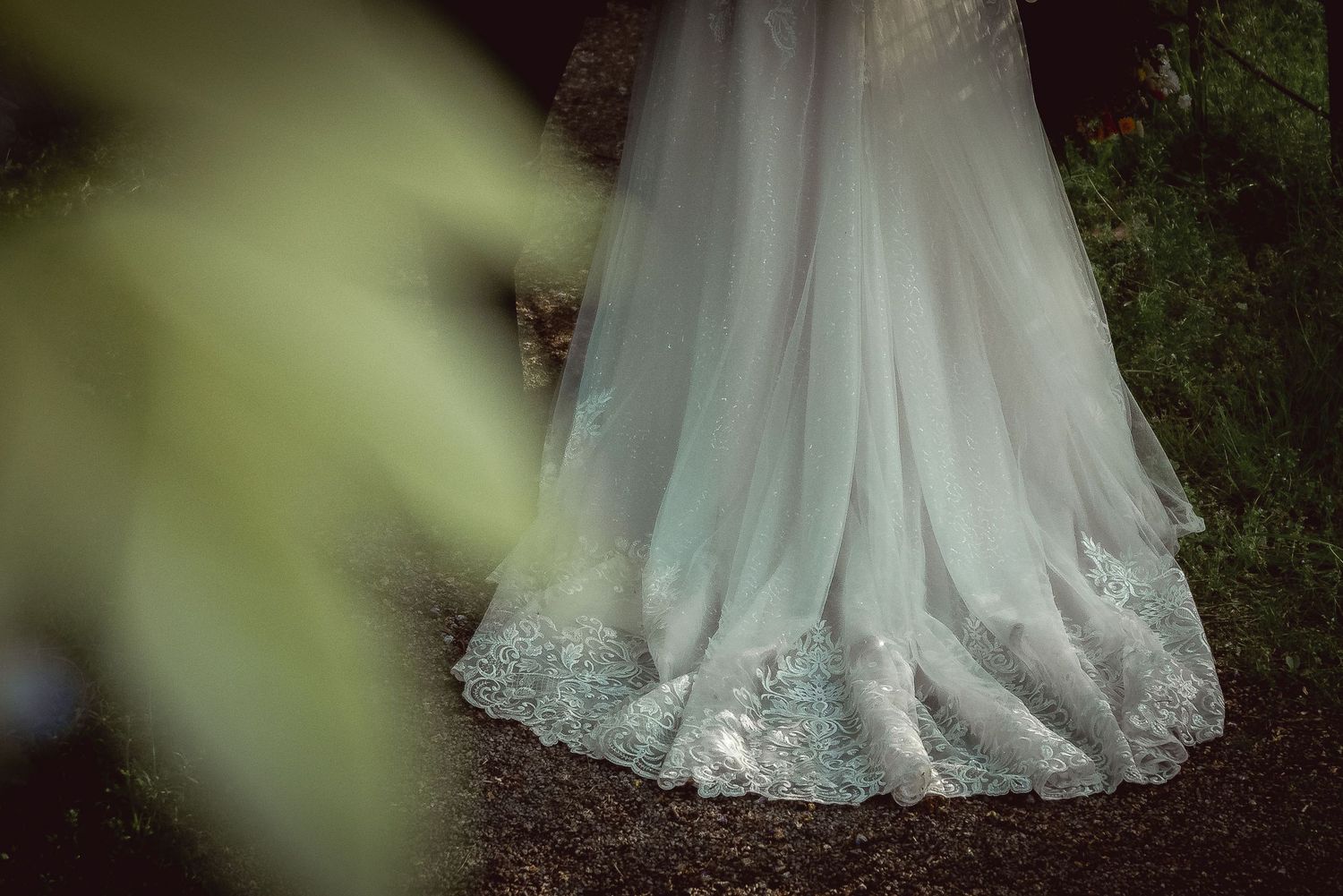 Close-up detail of an elegant white wedding gown with intricate lace trim.