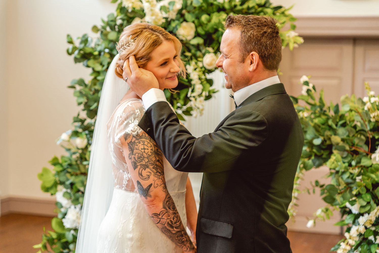 Sweet moment of Bride and Groom at the alter. Groom tucking her hair behind her ear