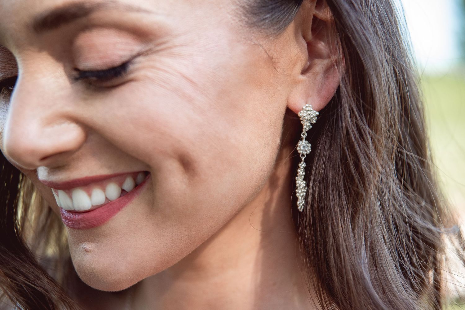 Close-up portrait showing elegant bridal jewelry and makeup details.