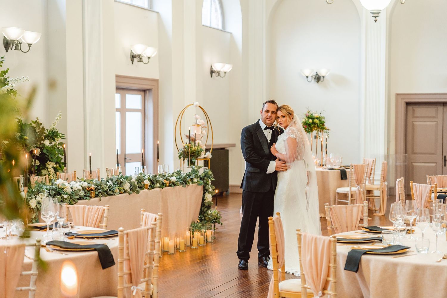 Bride and Groom posing in the centre of decorated reception room