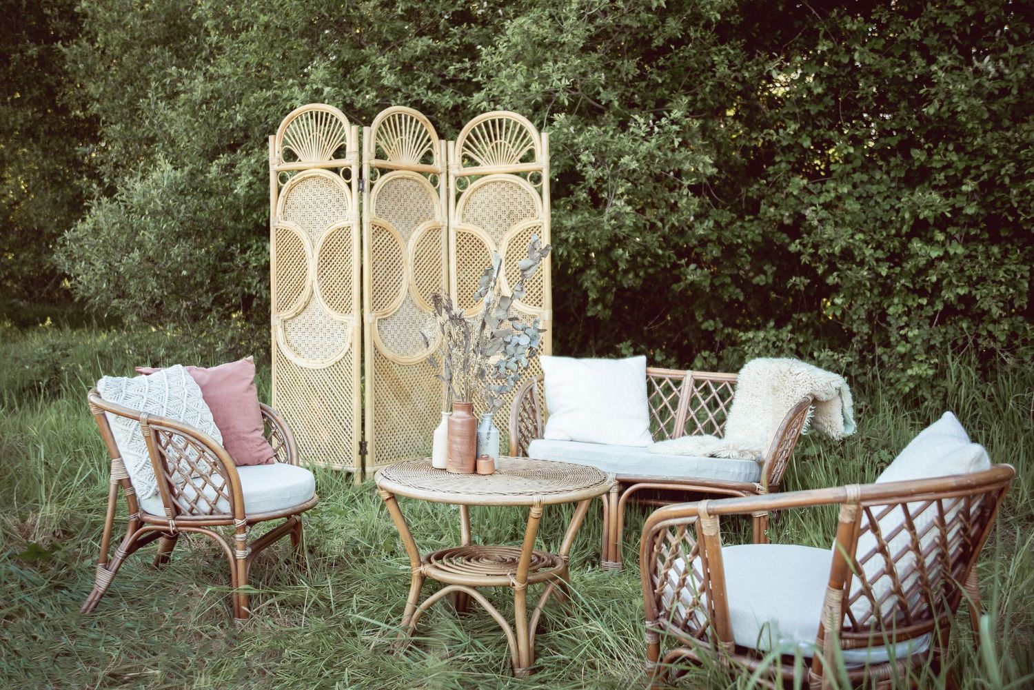 Bohemian outdoor lounge area with peacock chairs and vintage furniture for wedding photography.