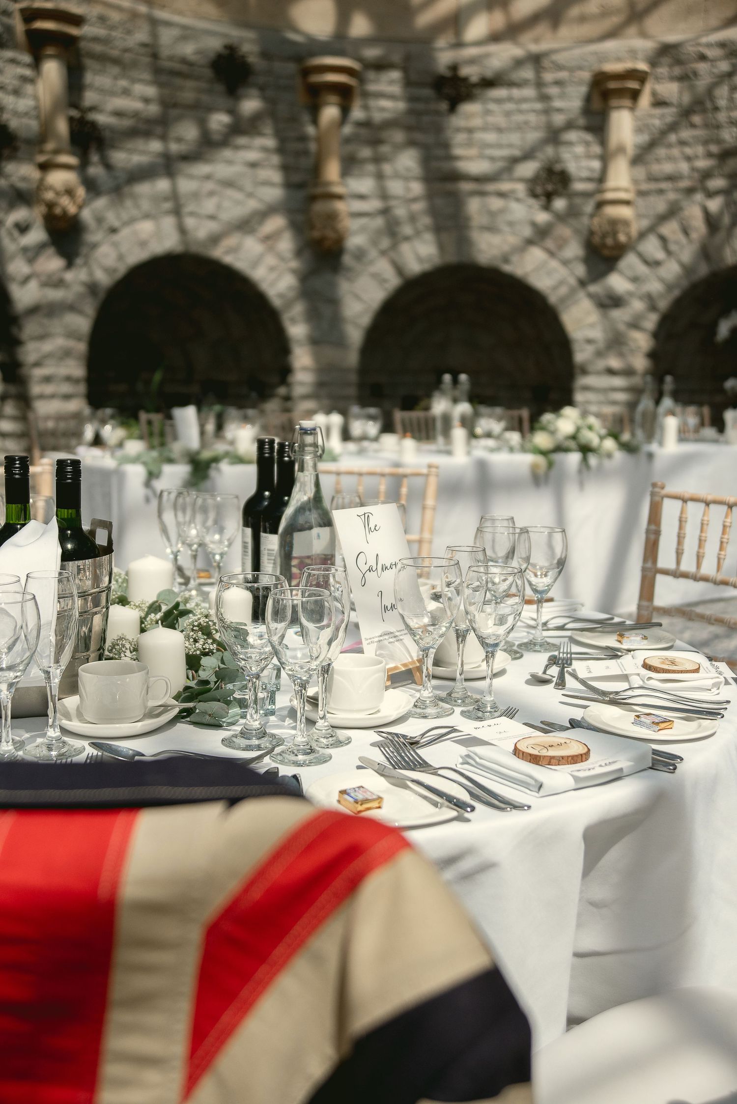Elegant wedding reception table settings with white linens and wine glasses.