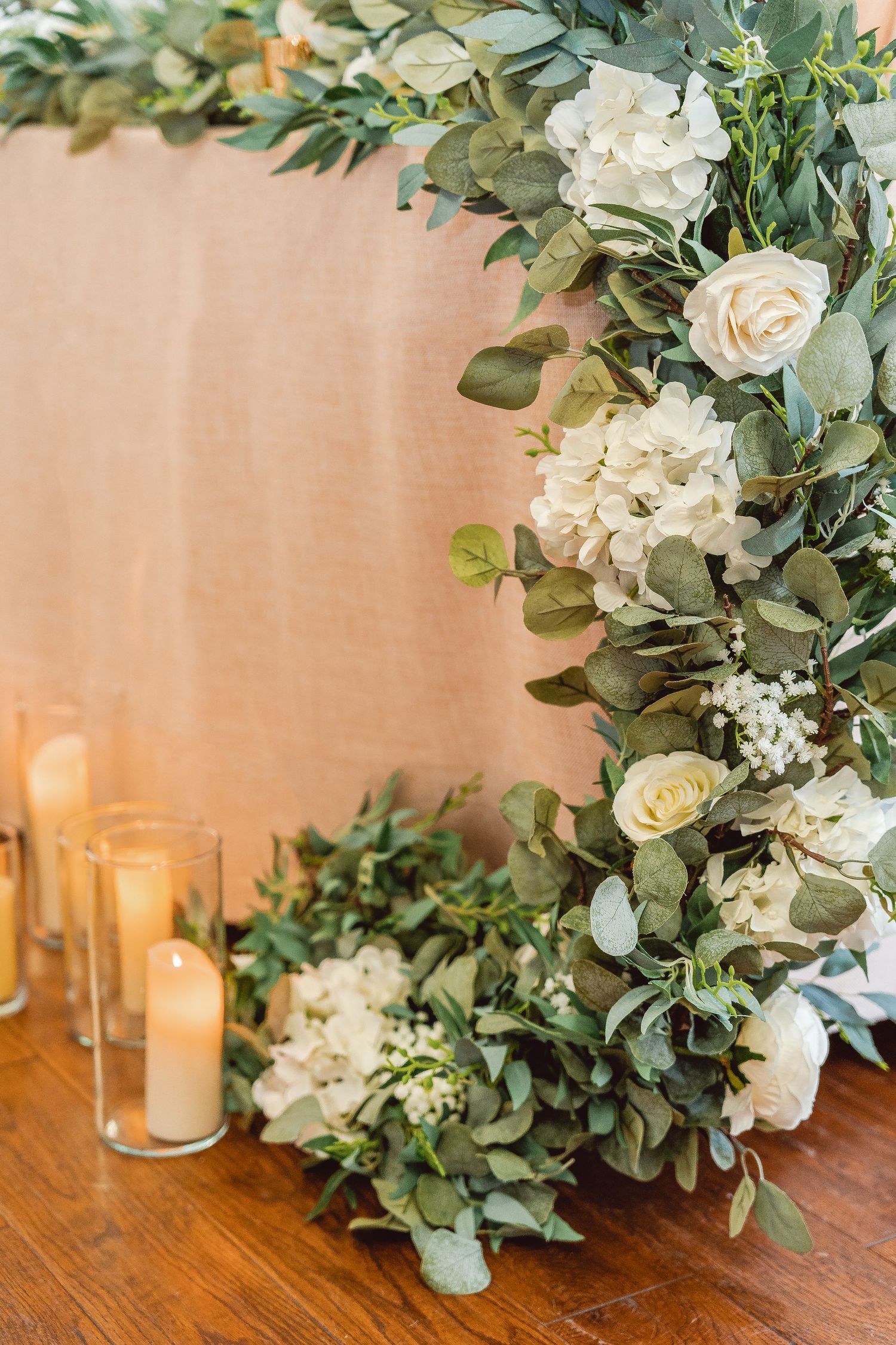 Detail on greenery garland draping off the table and candles along the length of table