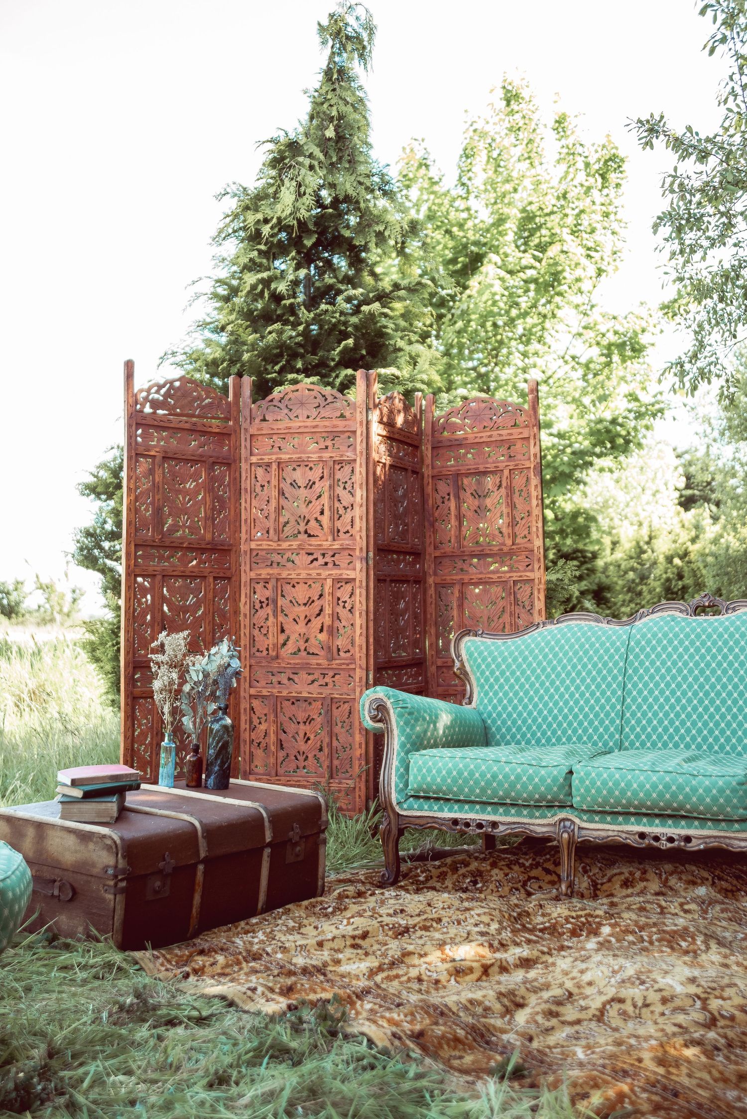 Vintage wooden screens and teal furniture create a romantic outdoor wedding photo backdrop.