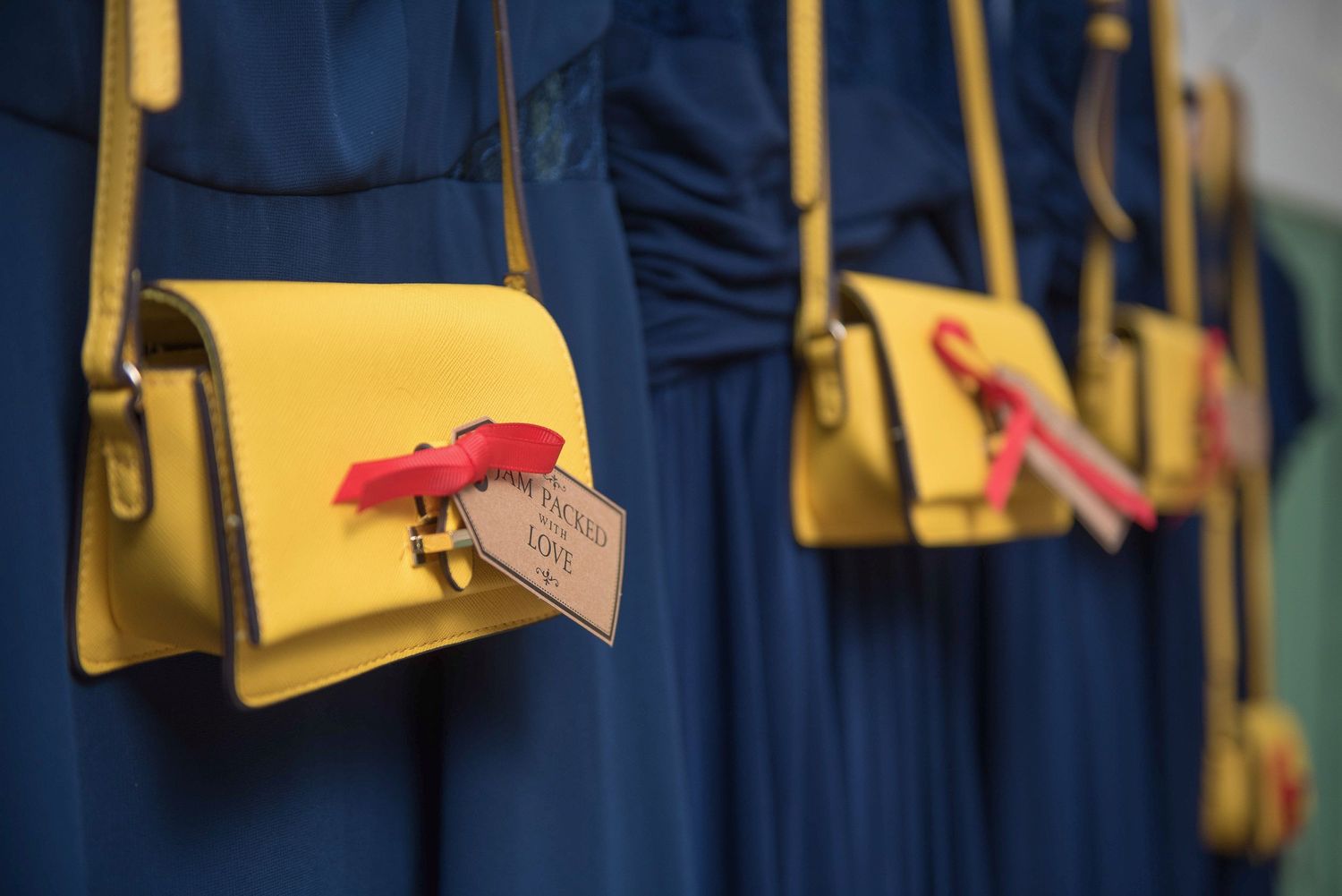 Close up of Bridesmaid gifts custom yellow bags and navy blue dresses