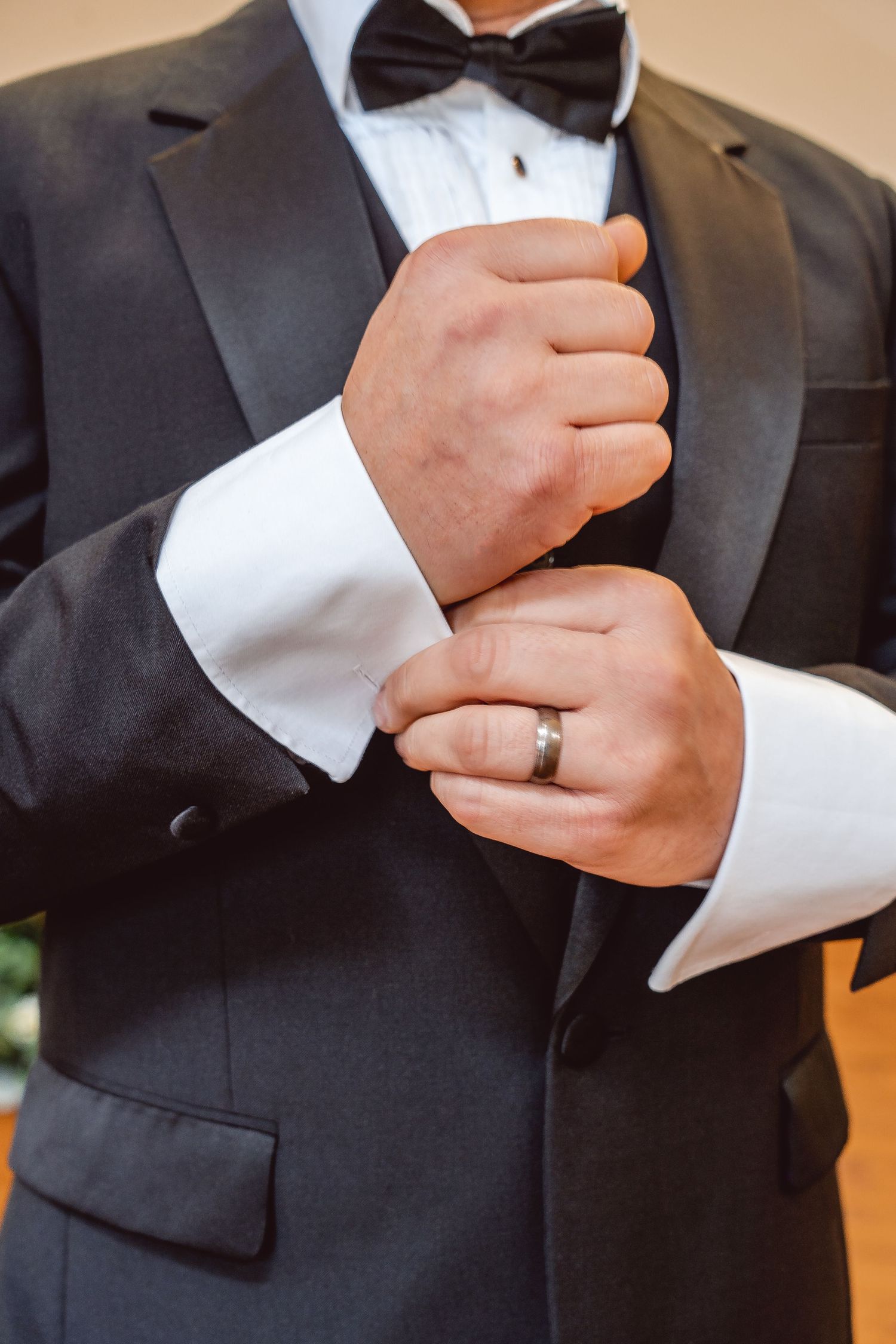 Close up of Groom holding the cuff of his tuxedo