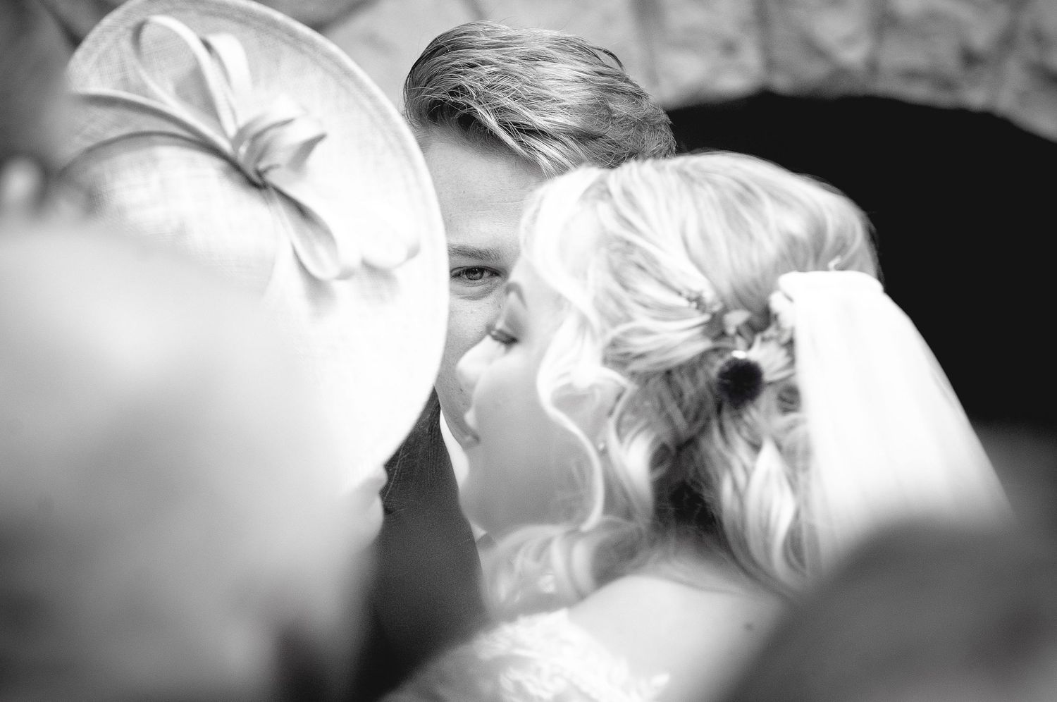 Intimate black and white portrait of a wedding couple's tender kiss.