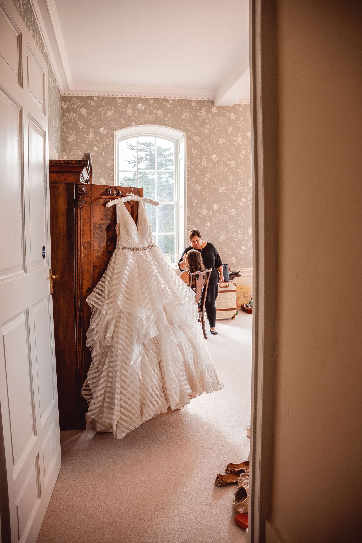 Long shot of hanging wedding dress with layered handkerchief skirt