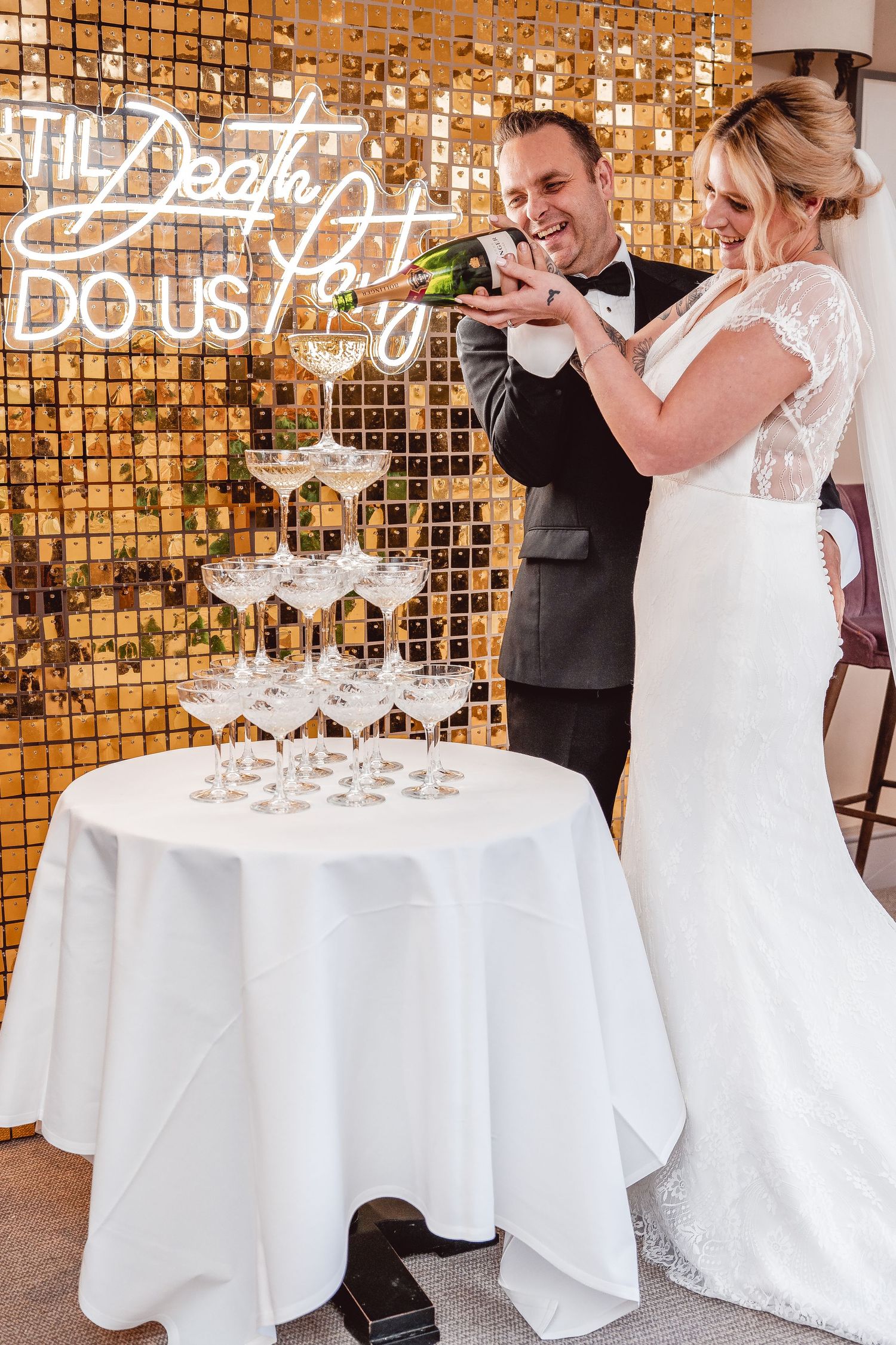 Bride and groom pouring champagne at the top of the Champagne tower
