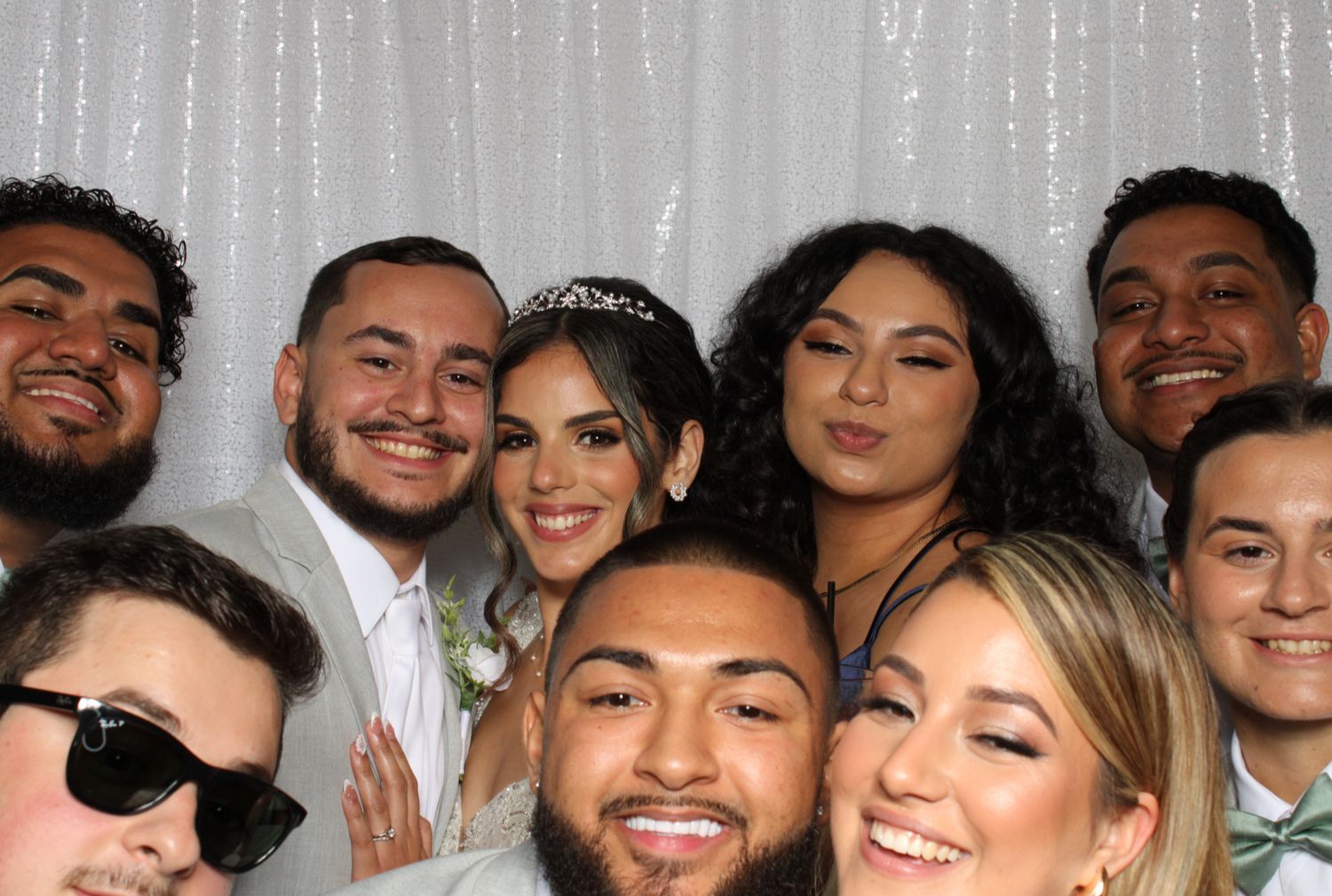 Photo booth strip showing multiple group shots from wedding celebration.