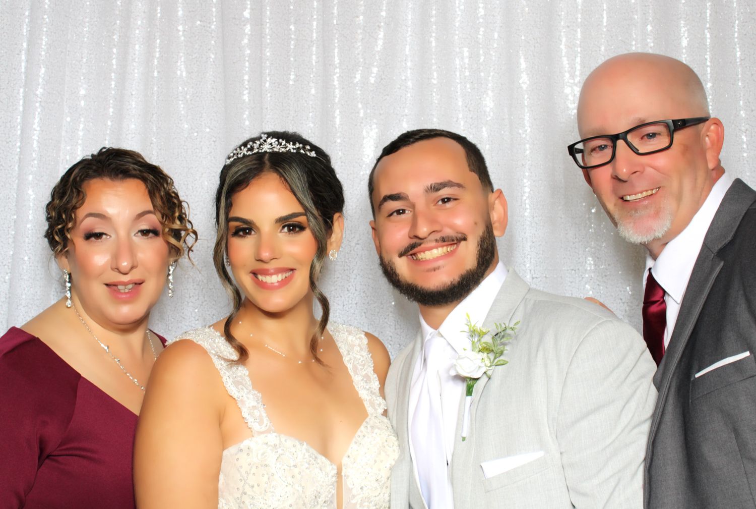 Large group photo booth shot of wedding party against silver backdrop.