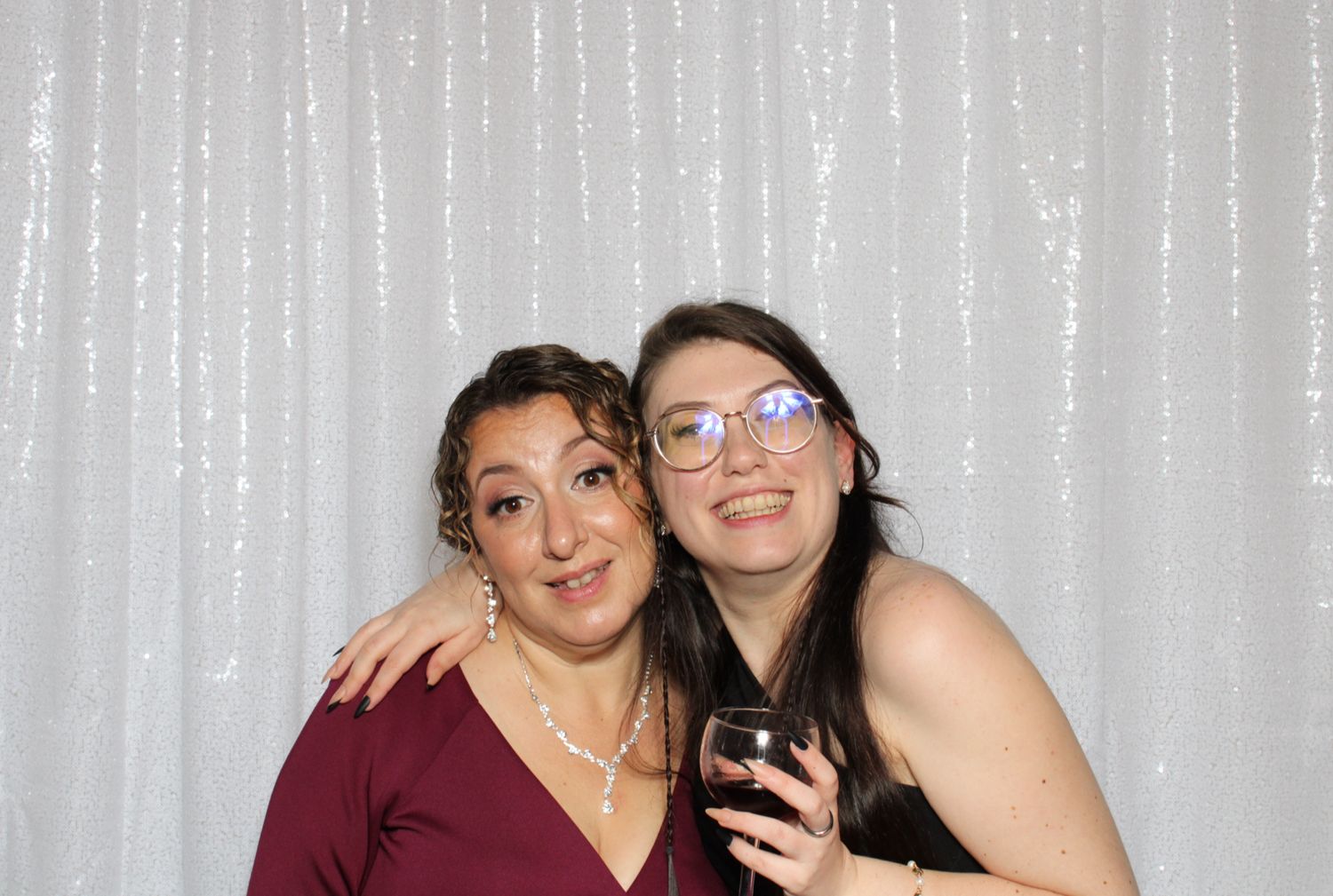 Four photo booth style images showing friends posing together with festive smiles against a silver backdrop.