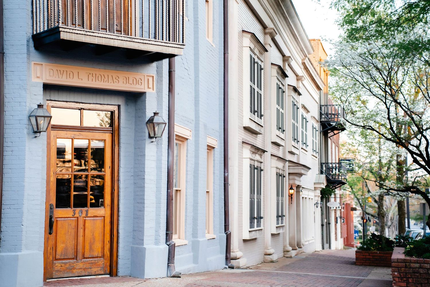 Charming historic blue building entrance with wooden doors and warm lighting on cobblestone street.