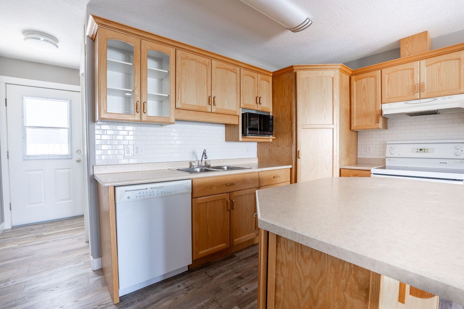 Modern kitchen interior real estate photography in Saskatoon Saskatchewan featuring wood cabinets and bright space.