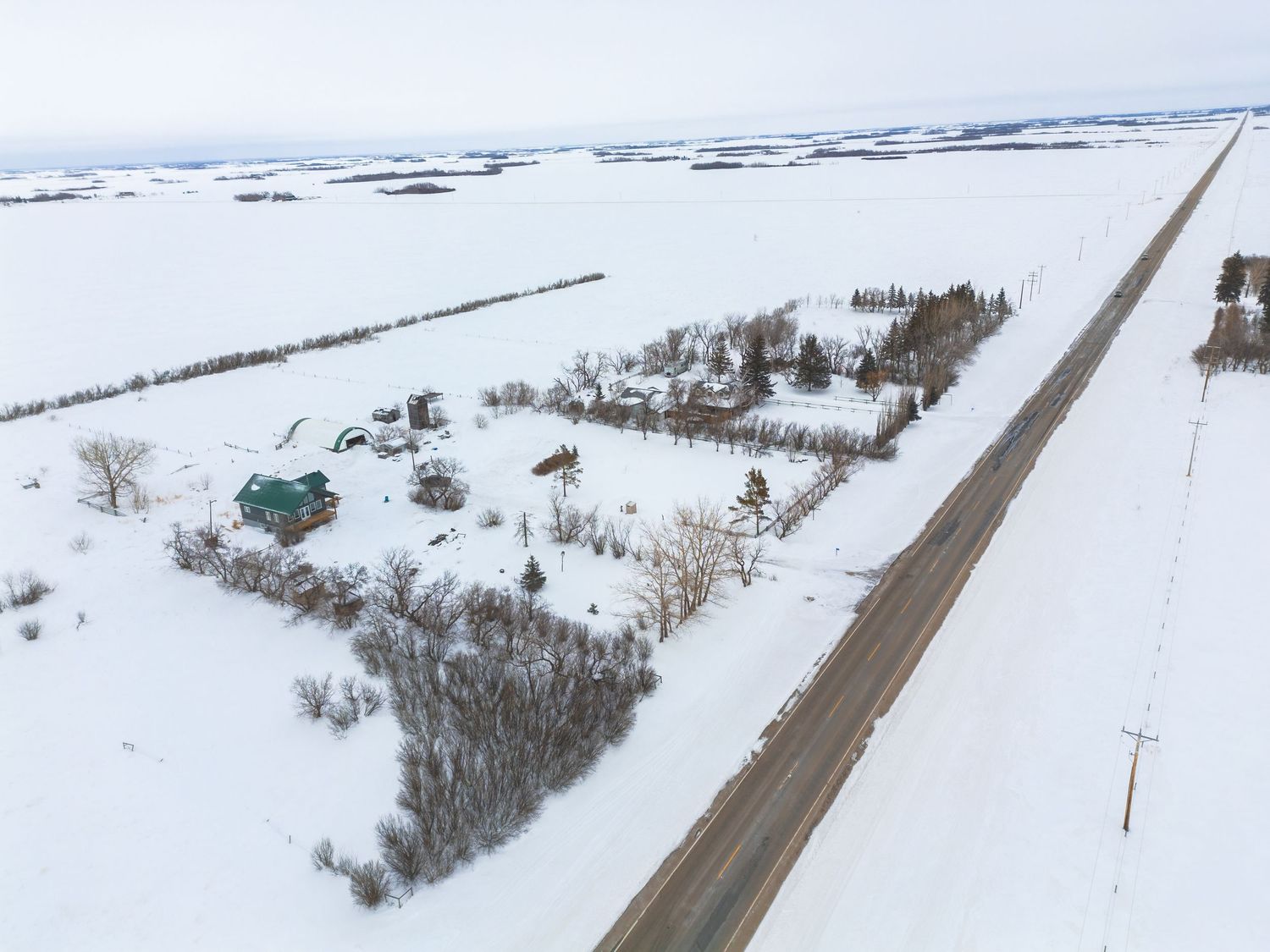 Snow covered neighborhood aerial real estate photography in Saskatoon Saskatchewan showing surrounding homes.