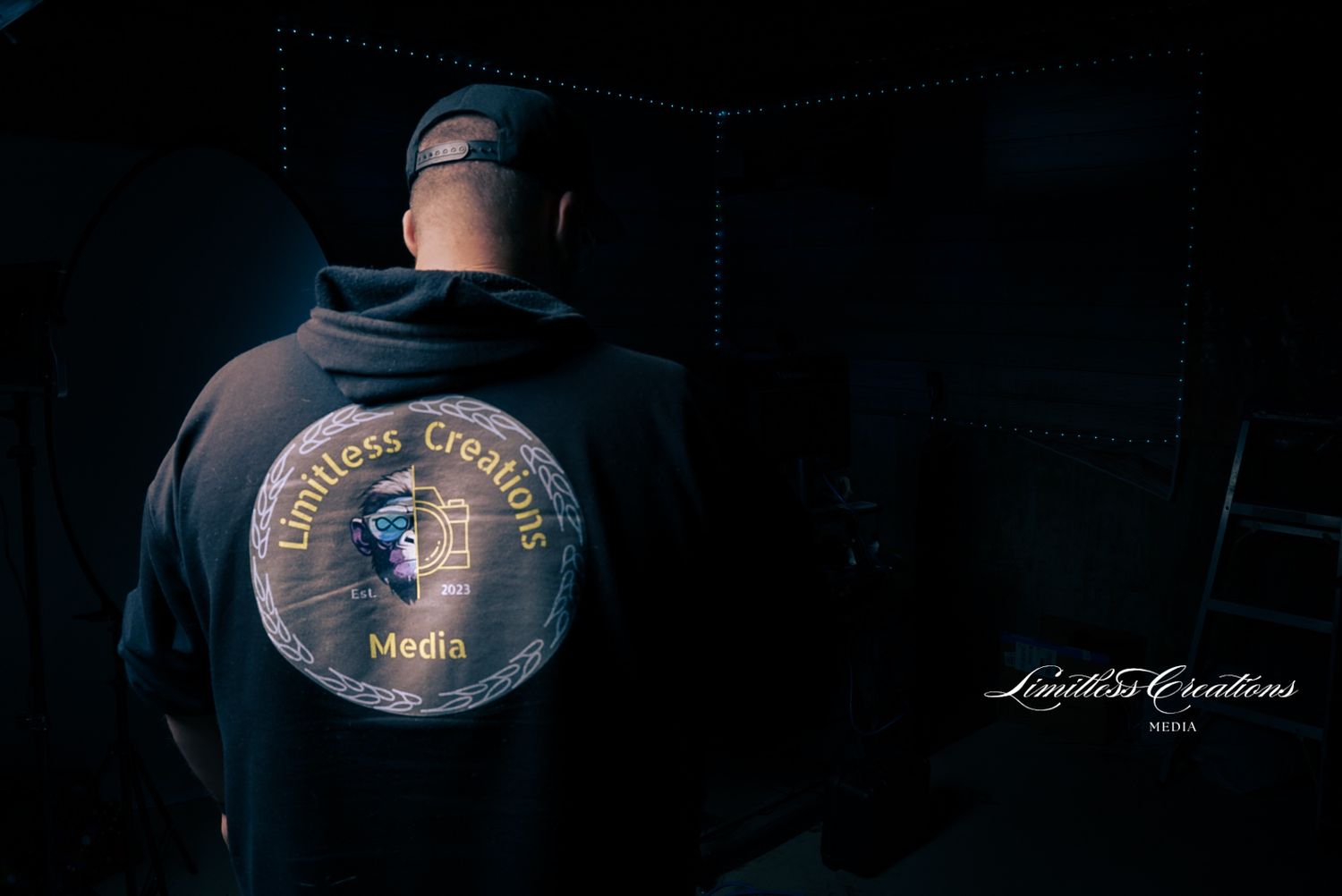 Dark and moody image on a unknown person wearing a limitless creations media hoody with the limitless creations media signature.