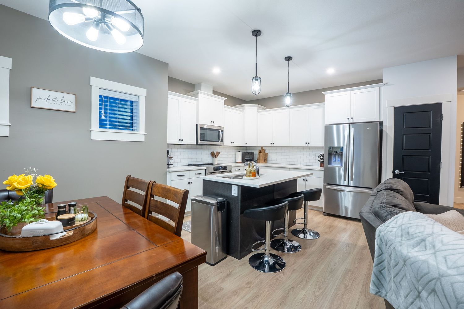 Modern kitchen real estate photography in Saskatoon Saskatchewan featuring white cabinets and open design.
