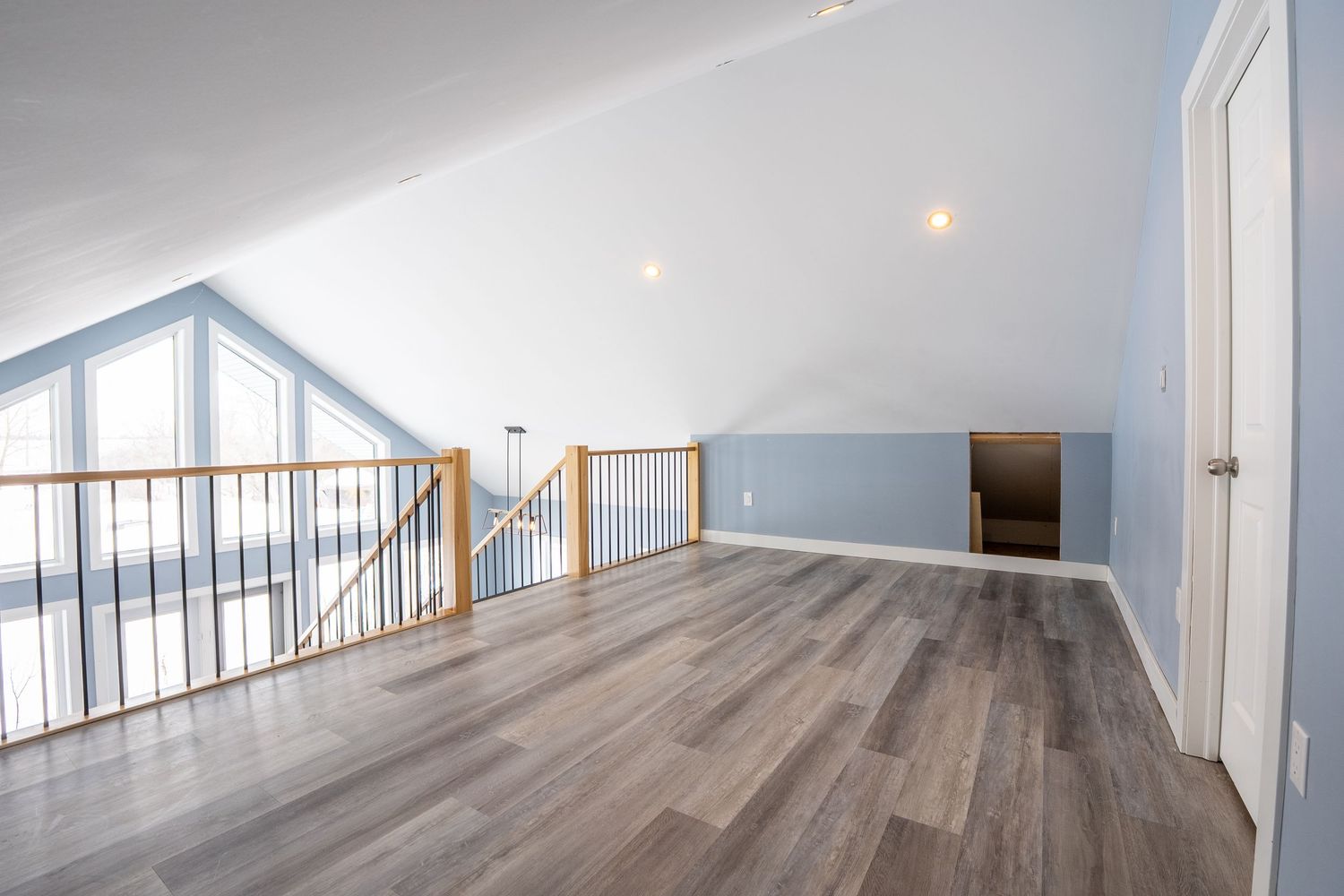 Open staircase and loft area real estate photography in Saskatoon Saskatchewan showing modern home layout.