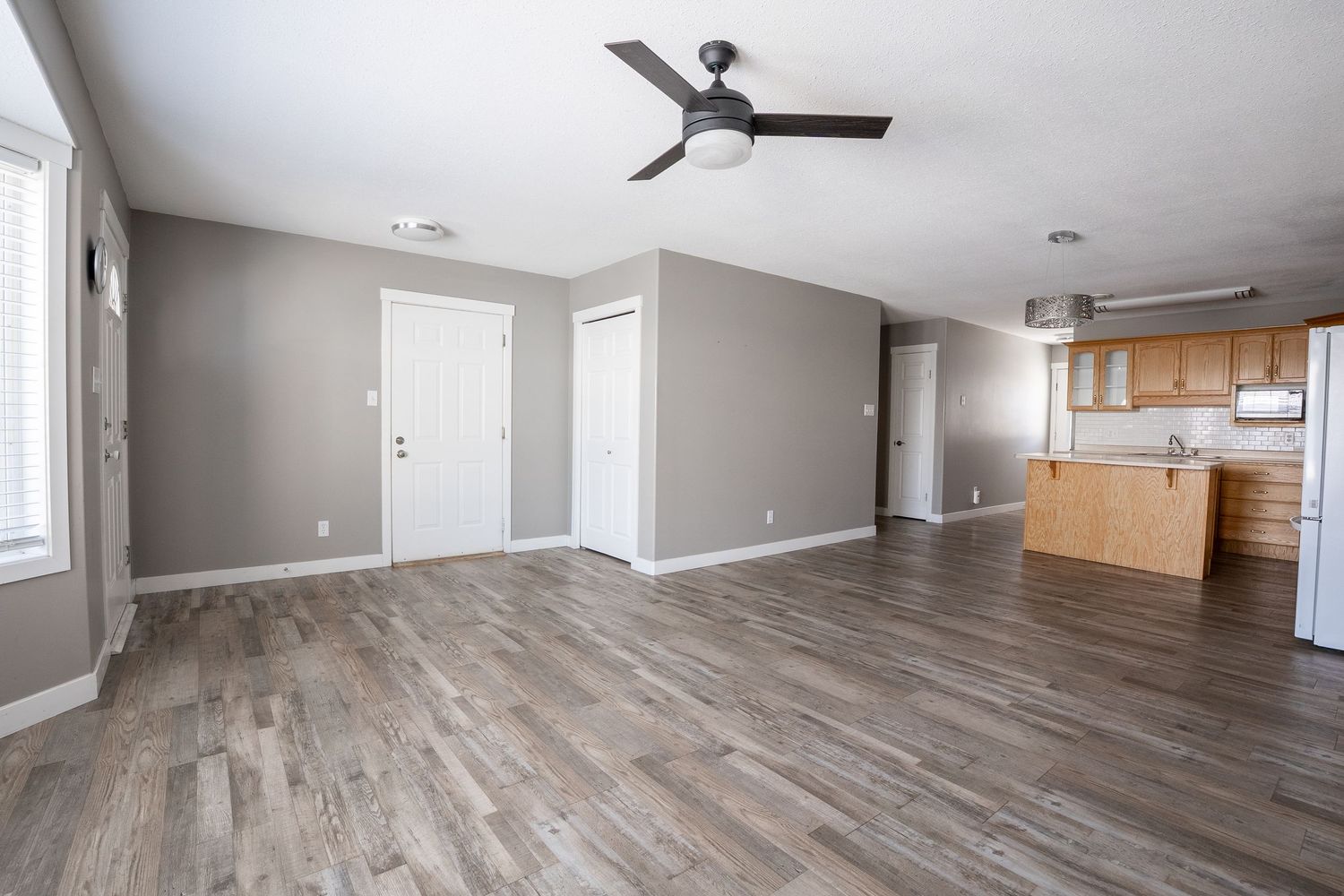 Spacious living room real estate photography in Saskatoon Saskatchewan with ceiling fan and large open floor layout.