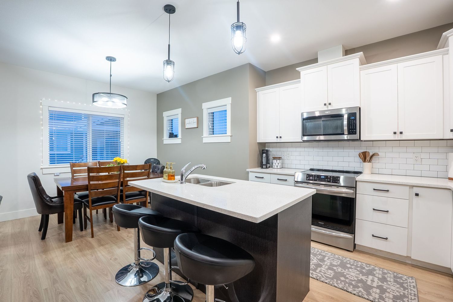 Modern kitchen real estate photography in Saskatoon Saskatchewan featuring white cabinets and open design.