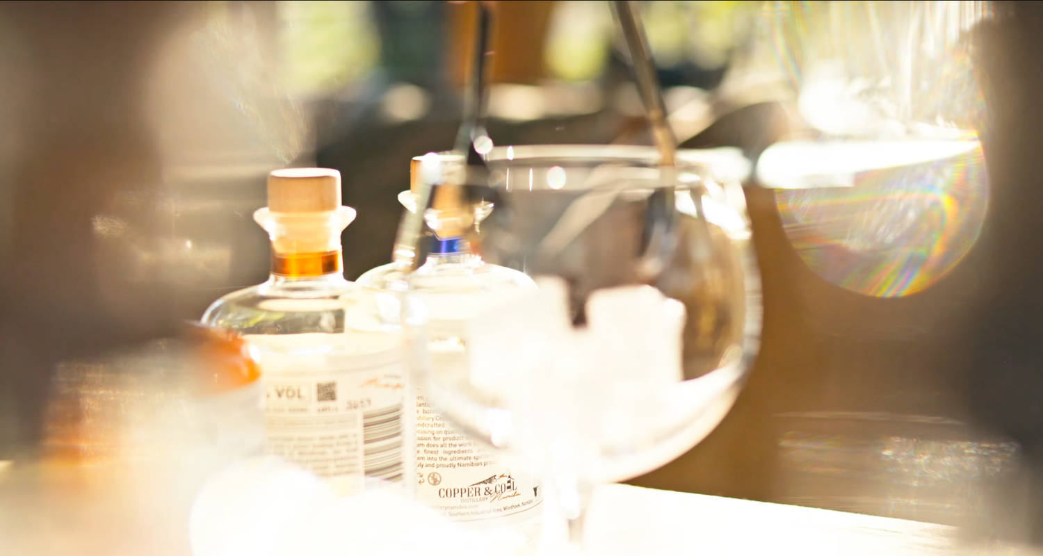 Laboratory glassware and reagent bottles on a bright, sunlit lab bench in a scientific research setting.