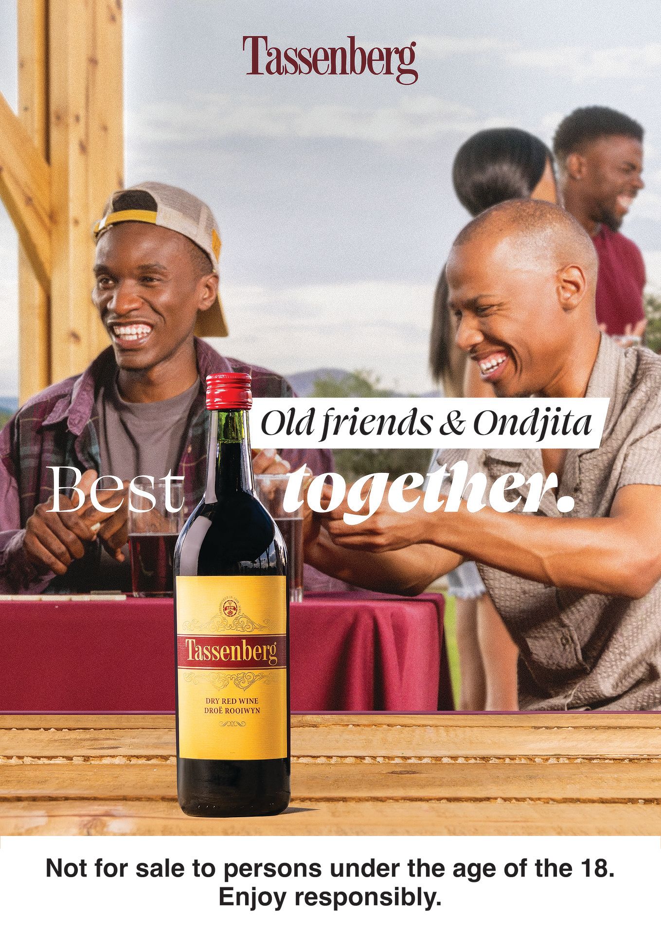 Tassenberg wine ad featuring two friends laughing outdoors with a bottle of red wine and the tagline Best together.