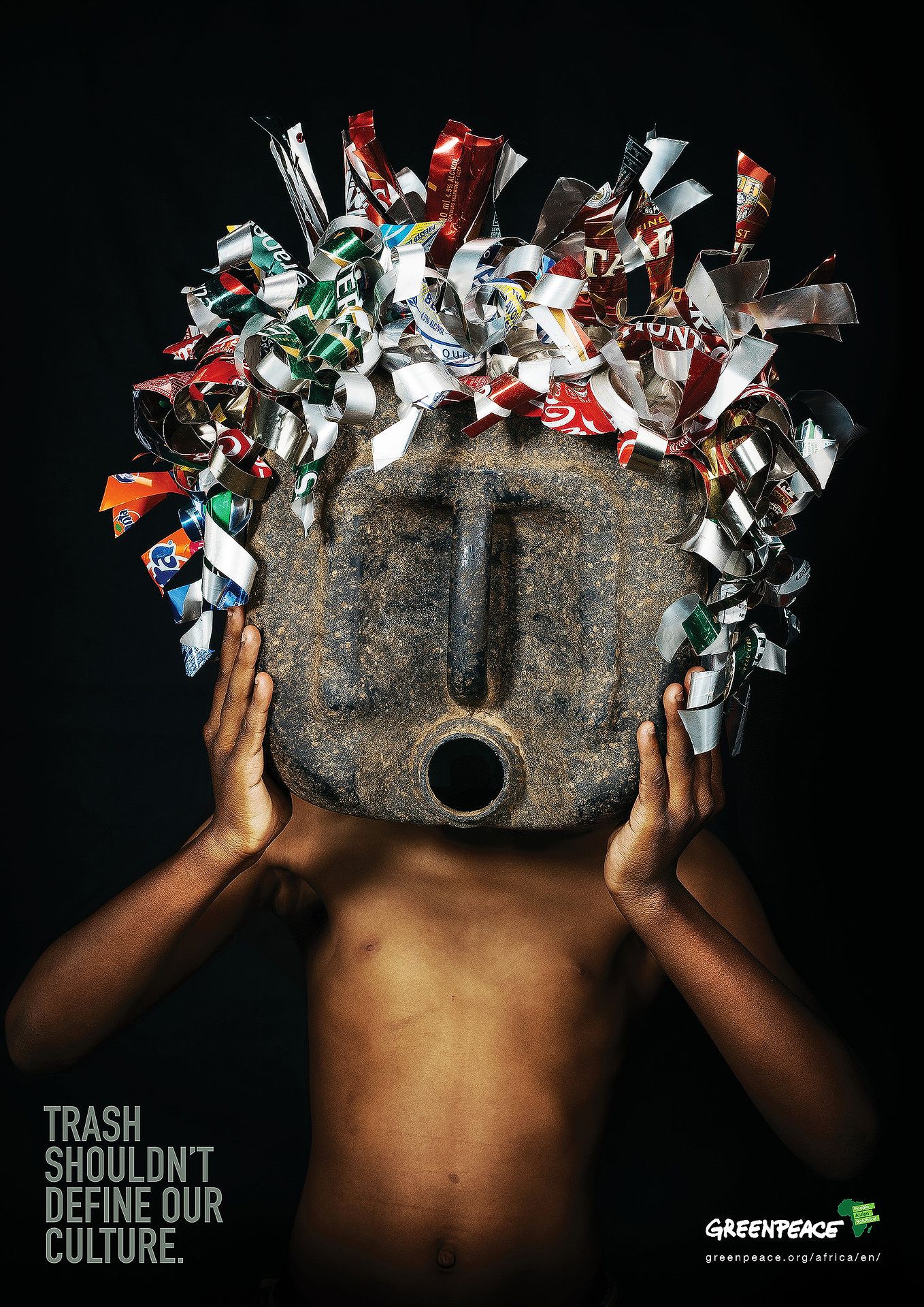 Greenpeace ad showing a child holding a stone mask adorned with trash, captioned Trash Shouldn't Define Our Culture.