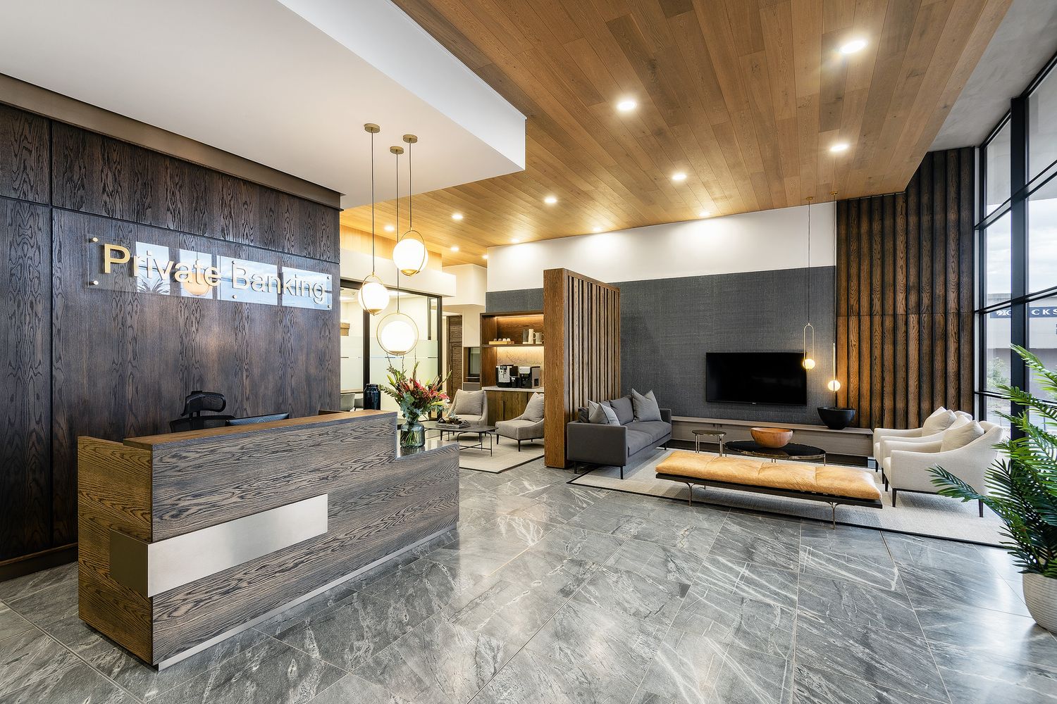 Luxury hotel reception with dark wood paneling, marble floors, pendant lighting, and elegant lounge seating area.