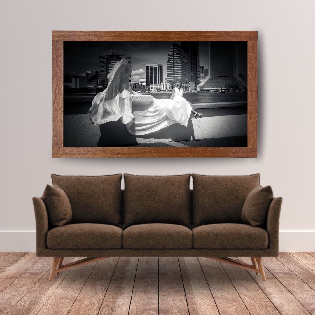 Black and white framed photo of a woman in a white flying dress in downtown Jacksonville, FL.