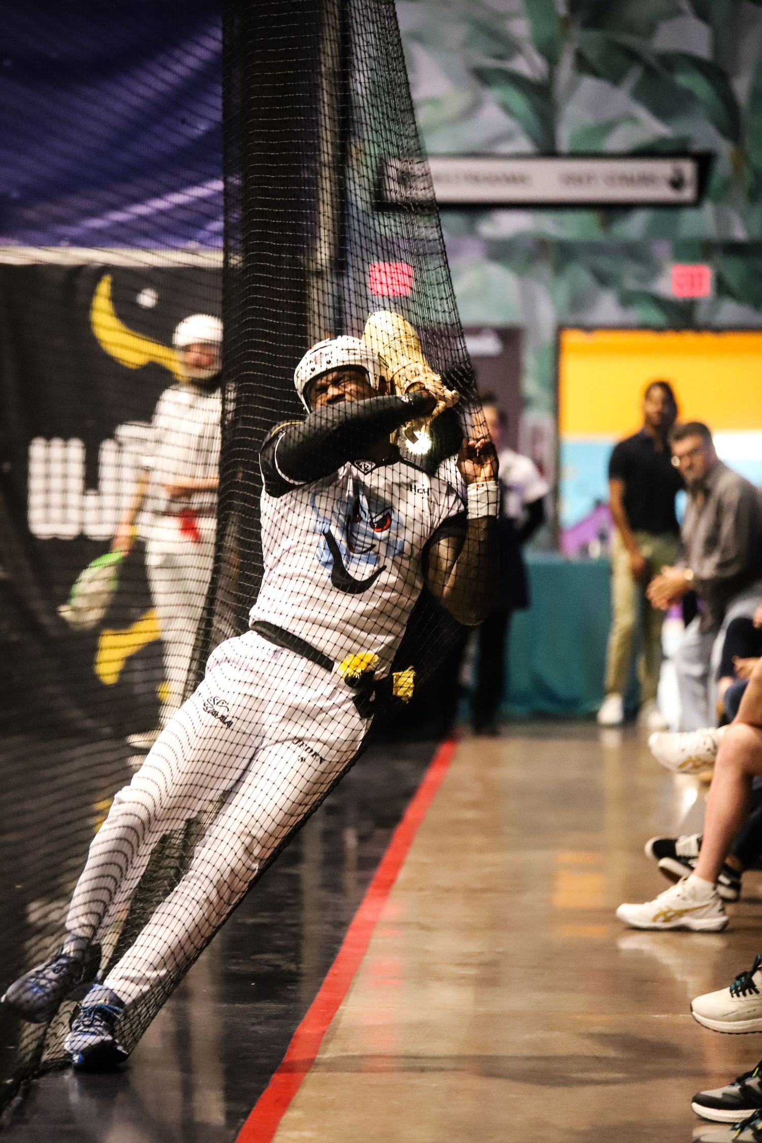 Jai Alai player wearing white uniform falling into the net