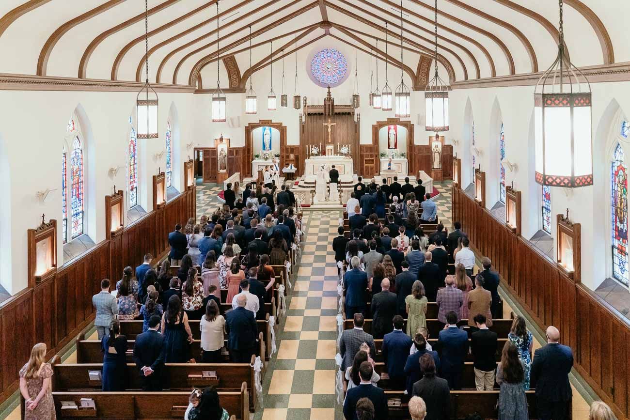Aerial view of a packed Catholic church congregation during a wedding ceremony with ornate decor.