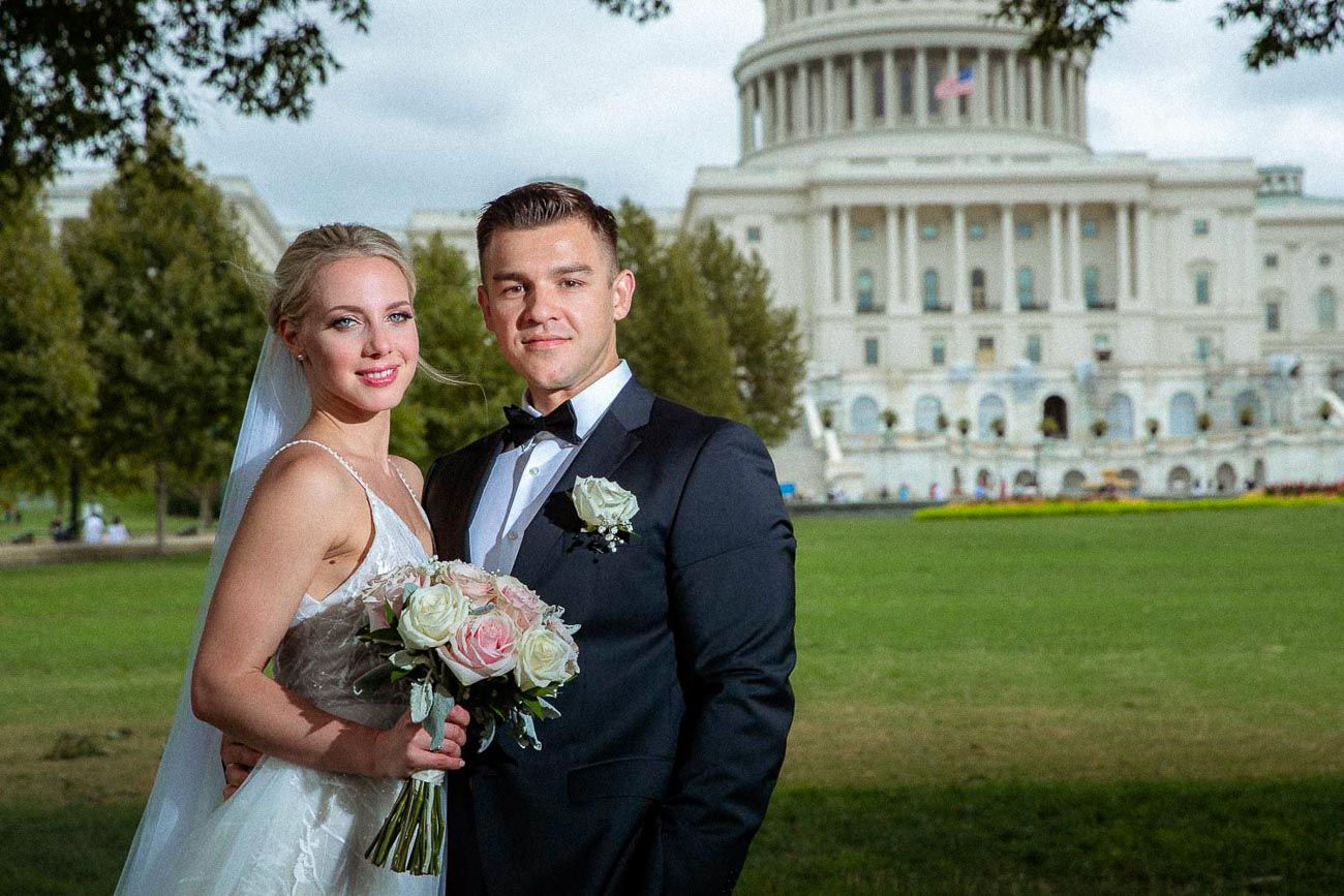 Happy newlyweds smiling together with the United States Capitol building in the background.