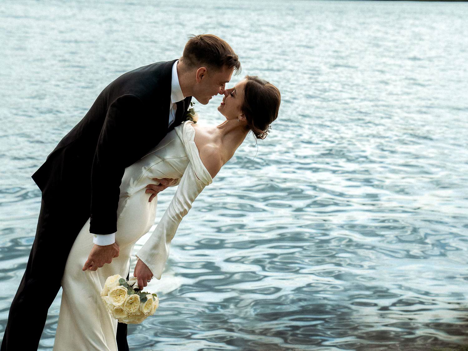 Bride and groom sharing romantic kiss at edge of Tidal Basin.