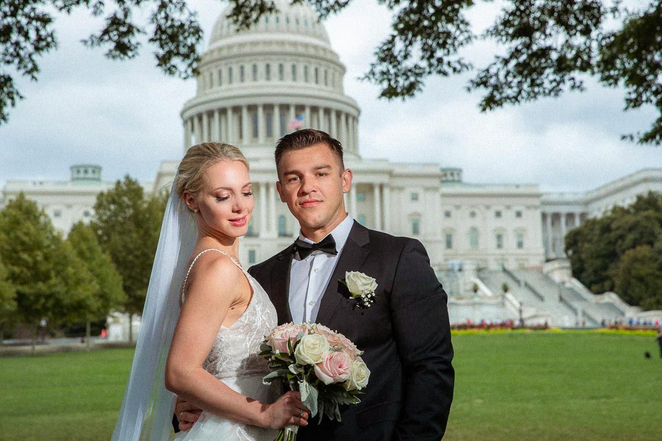 Bride and groom posing in front of the US Capitol building on their wedding day in Washington DC.