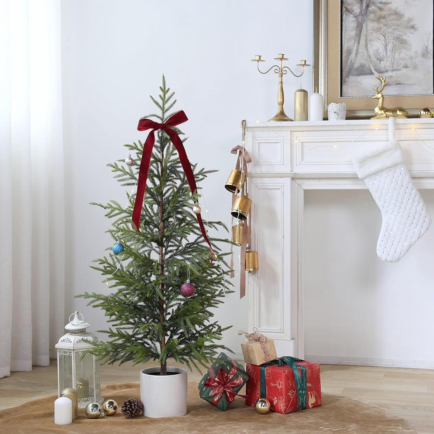 Modern living room corner decorated for Christmas with fresh pine tree, wrapped presents and neutral decor elements.