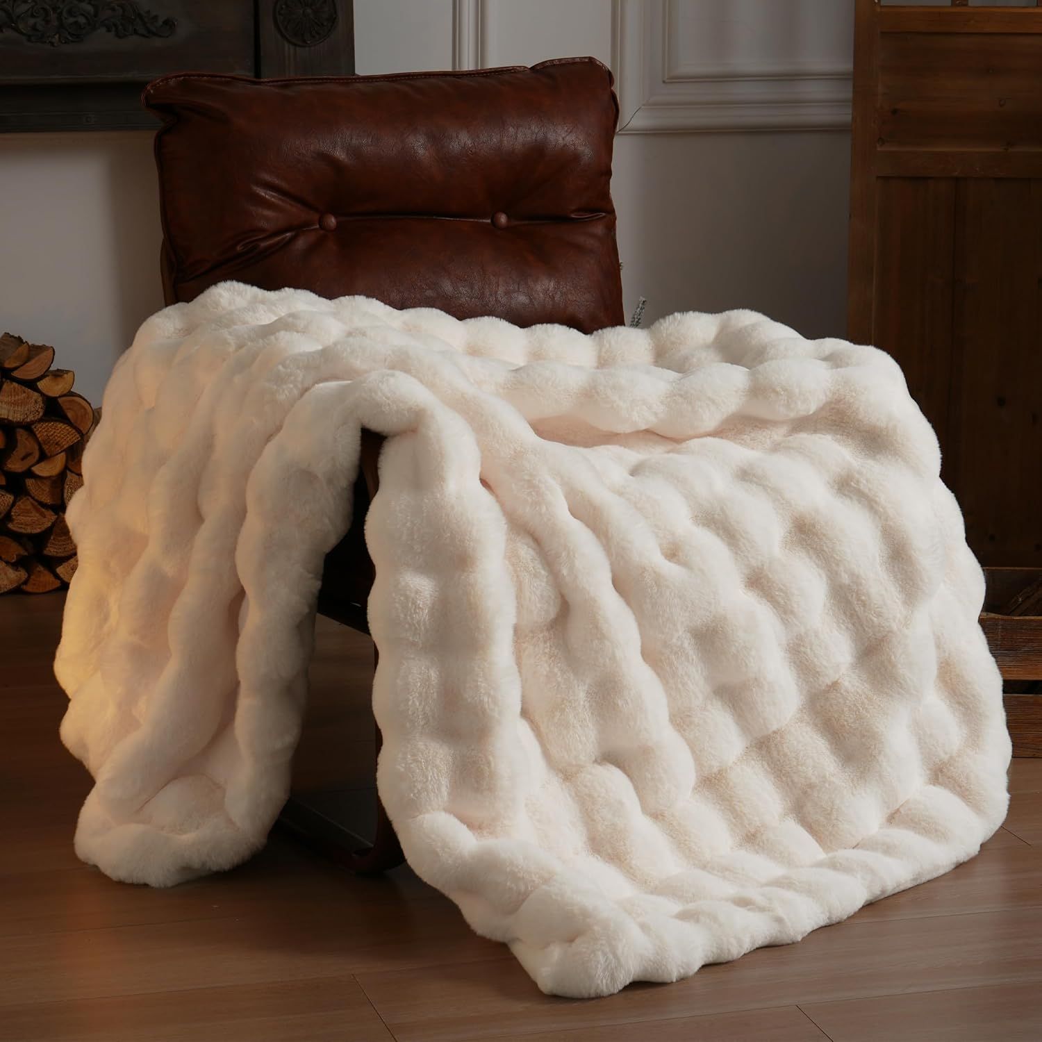 Luxurious plush white faux fur throw blanket with quilted texture draped over brown leather furniture near firewood storage.