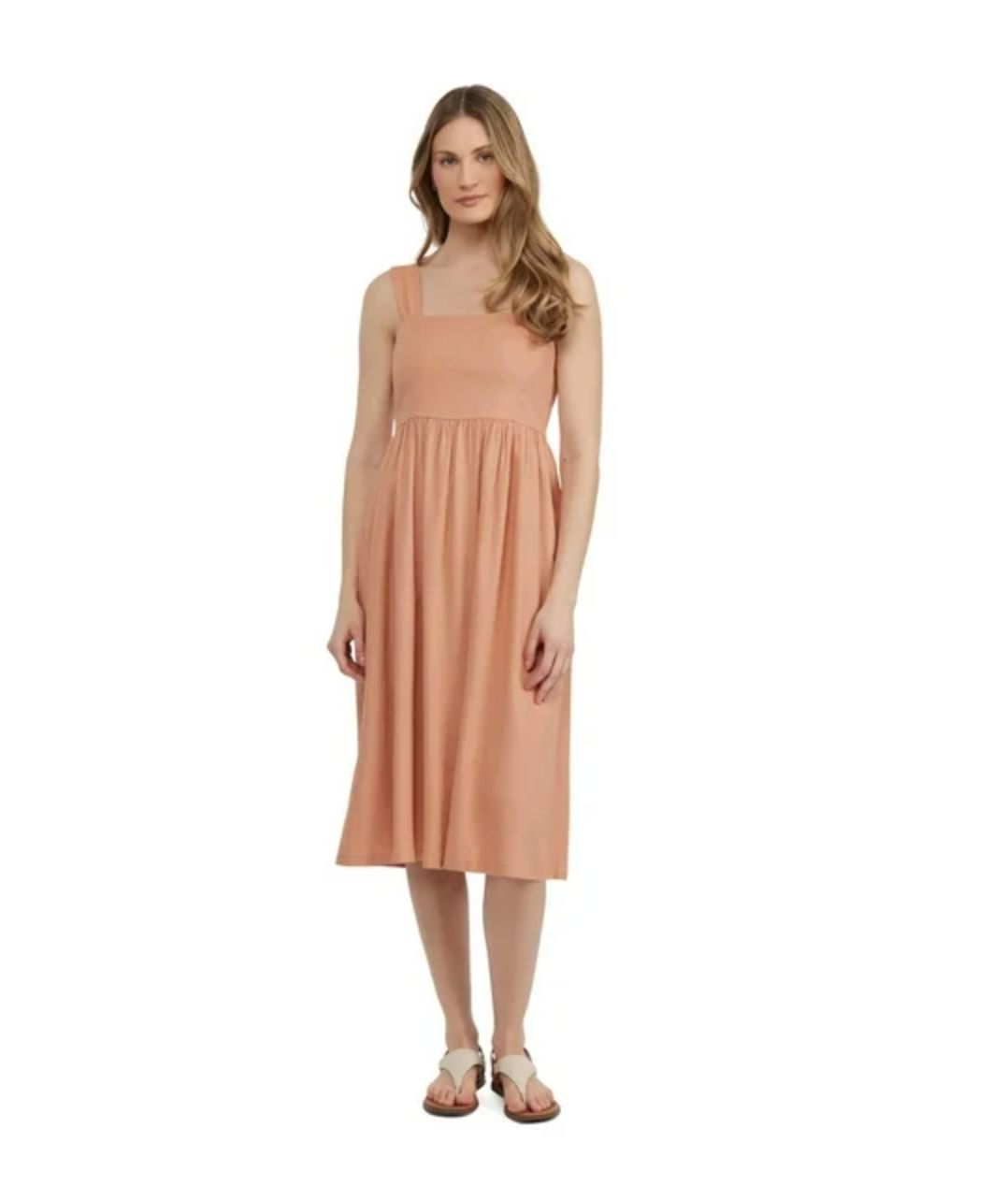 Sleeveless peach midi dress with empire waist and flowing skirt.