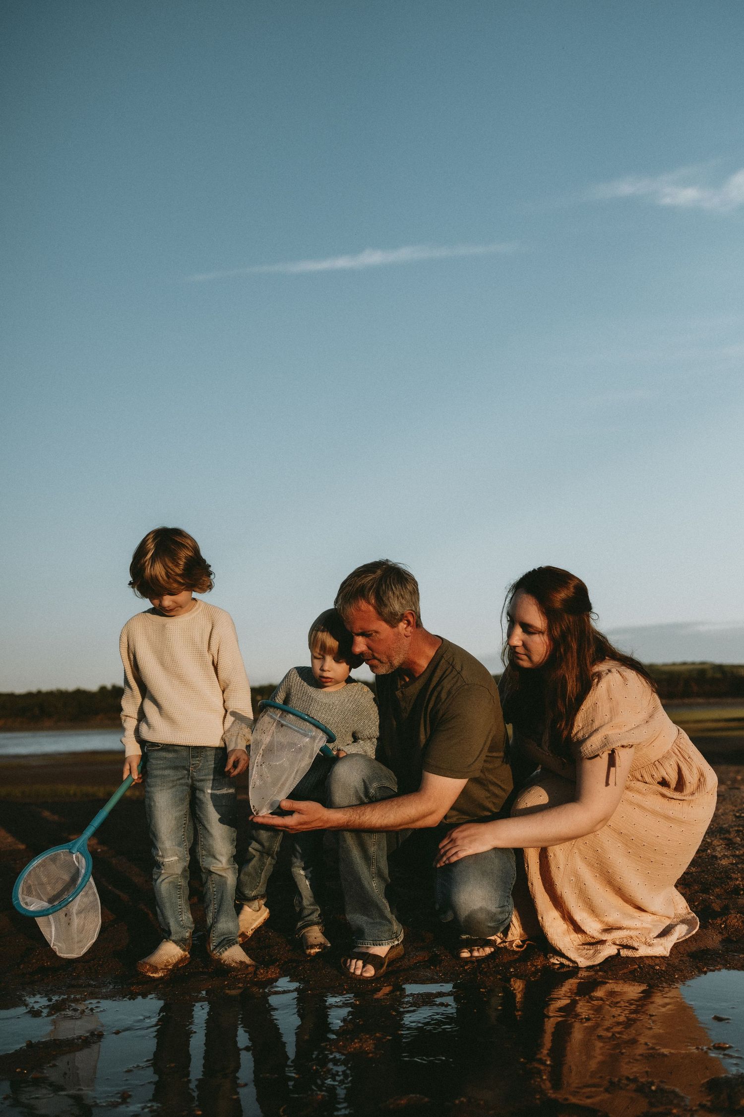 A family relaxing and playing in the tidal pool on  vacation at Avonport Beach in Nova Scotia